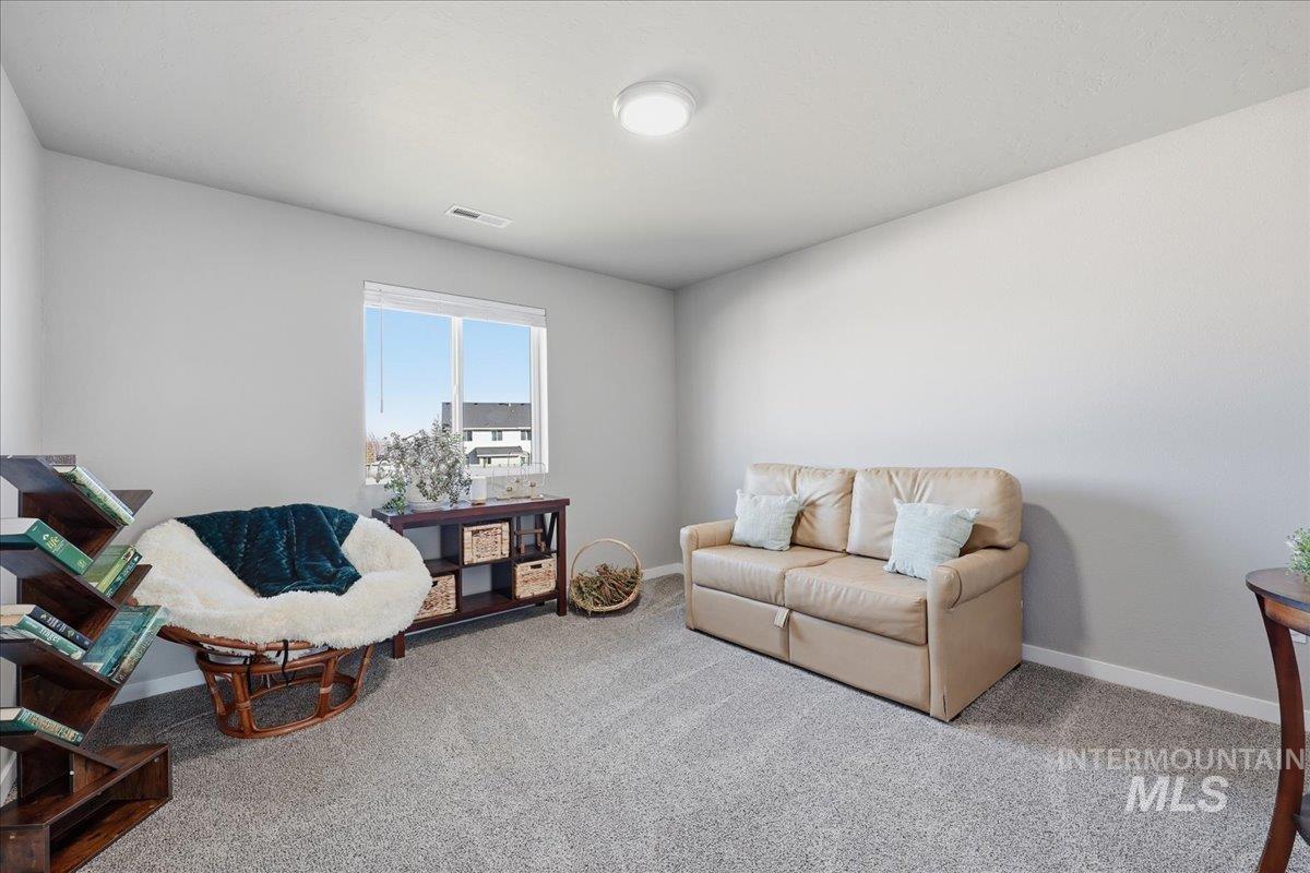 Carpeted living area featuring baseboards
