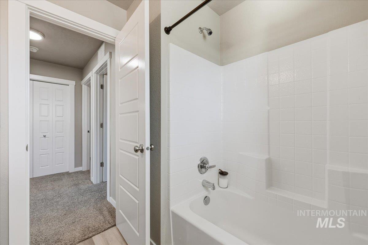 Bathroom with  shower combination and light colored carpet