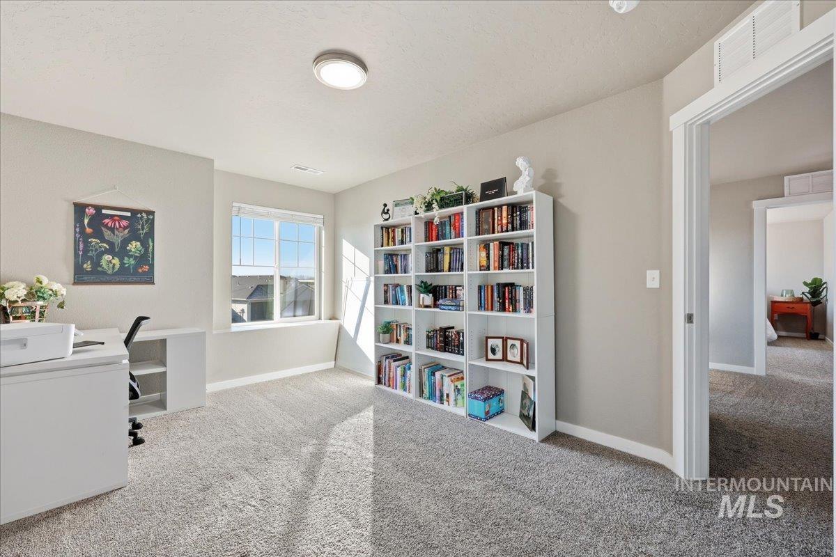 Office featuring light colored carpet and a textured ceiling