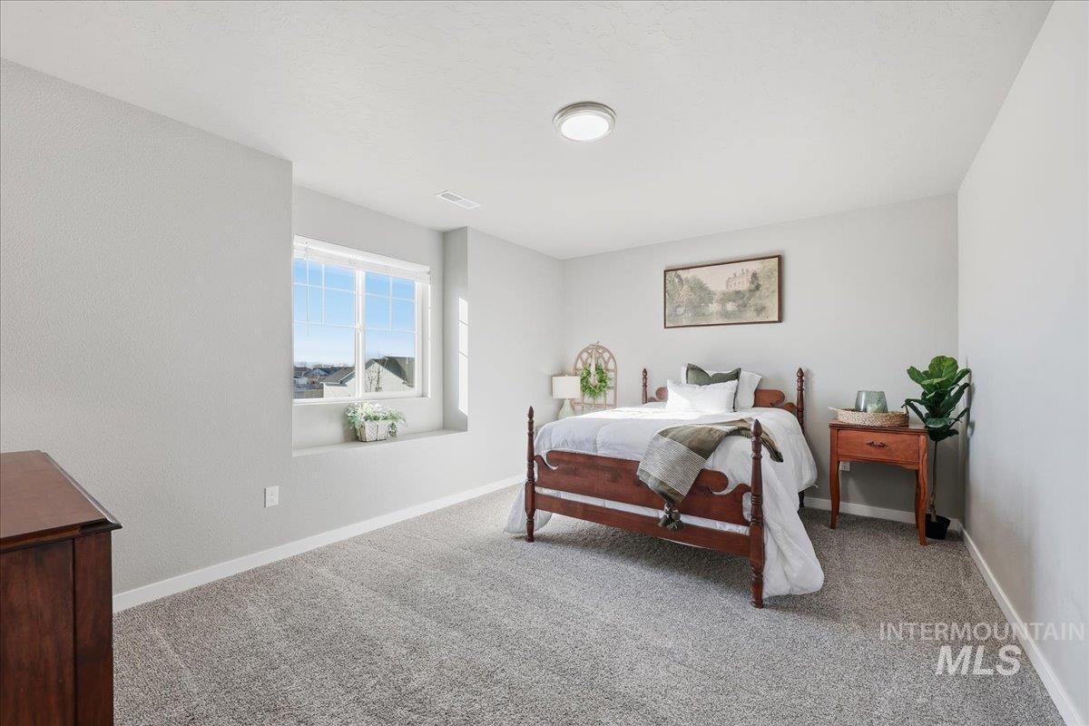 Bedroom featuring carpet floors and baseboards