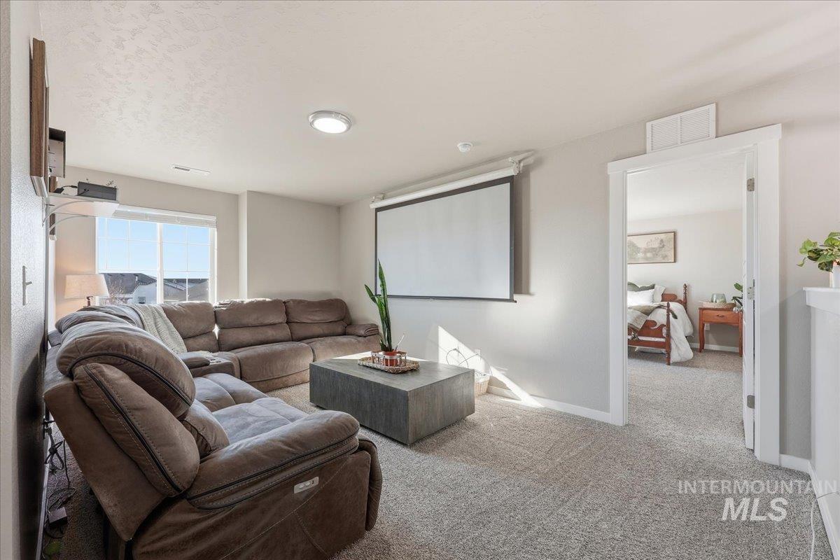 Carpeted living room with baseboards and a textured ceiling