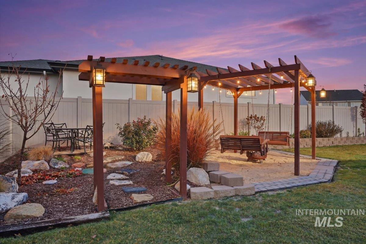 Patio terrace at dusk featuring a patio, a fenced backyard, and a pergola