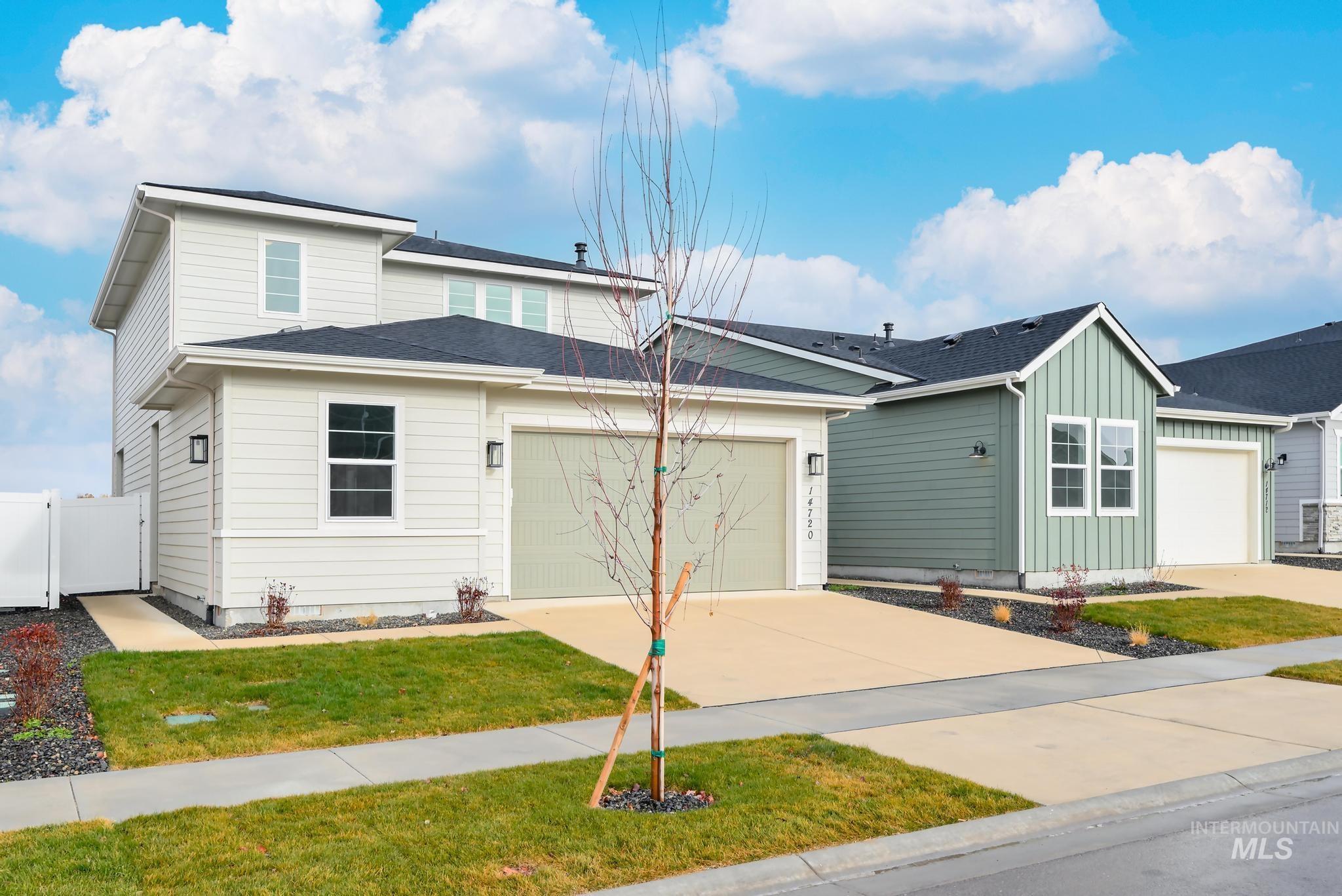 View of front of property featuring board and batten siding, concrete driveway, a garage, and roof with shingles