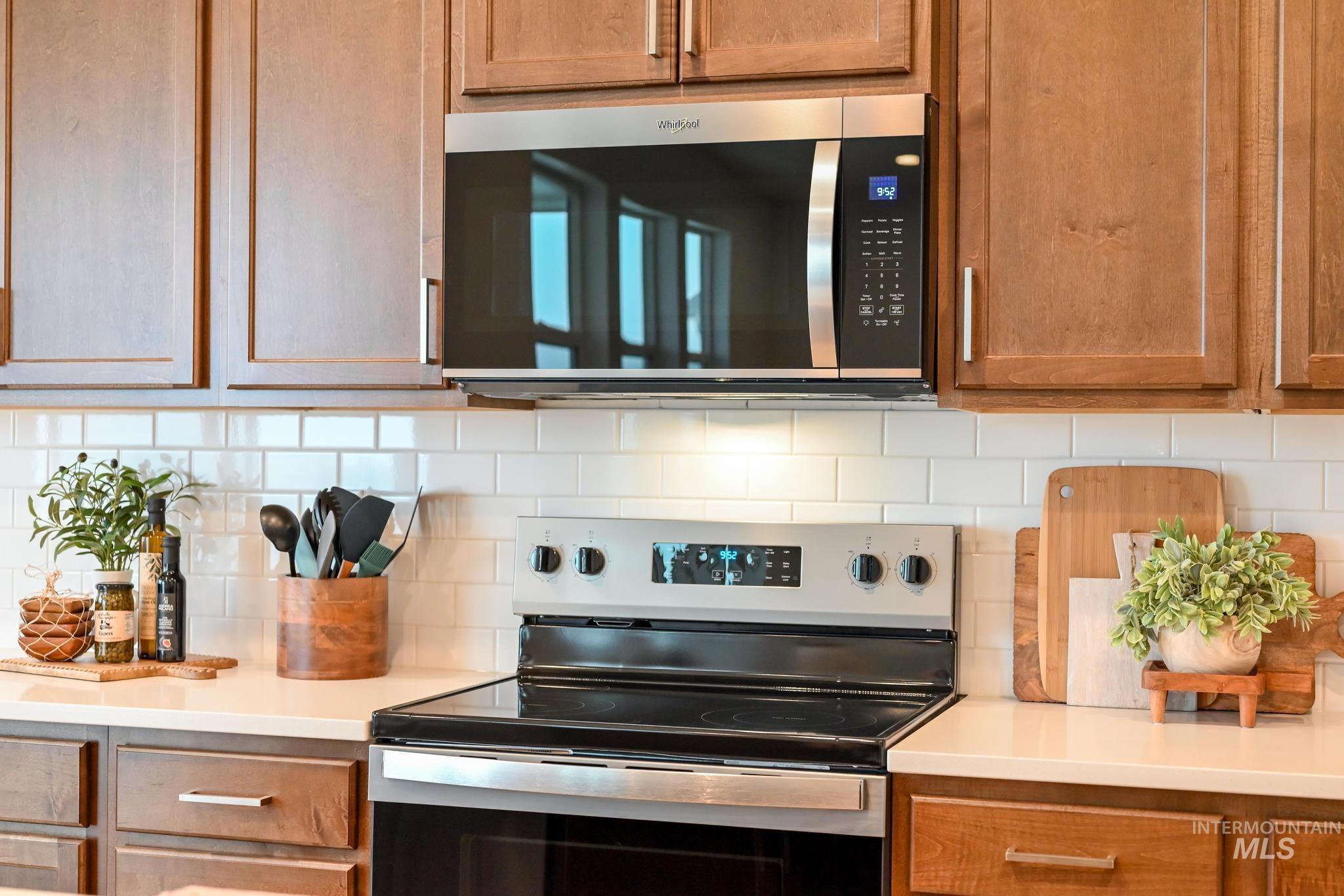 Kitchen featuring stainless steel appliances, backsplash, and brown cabinetry