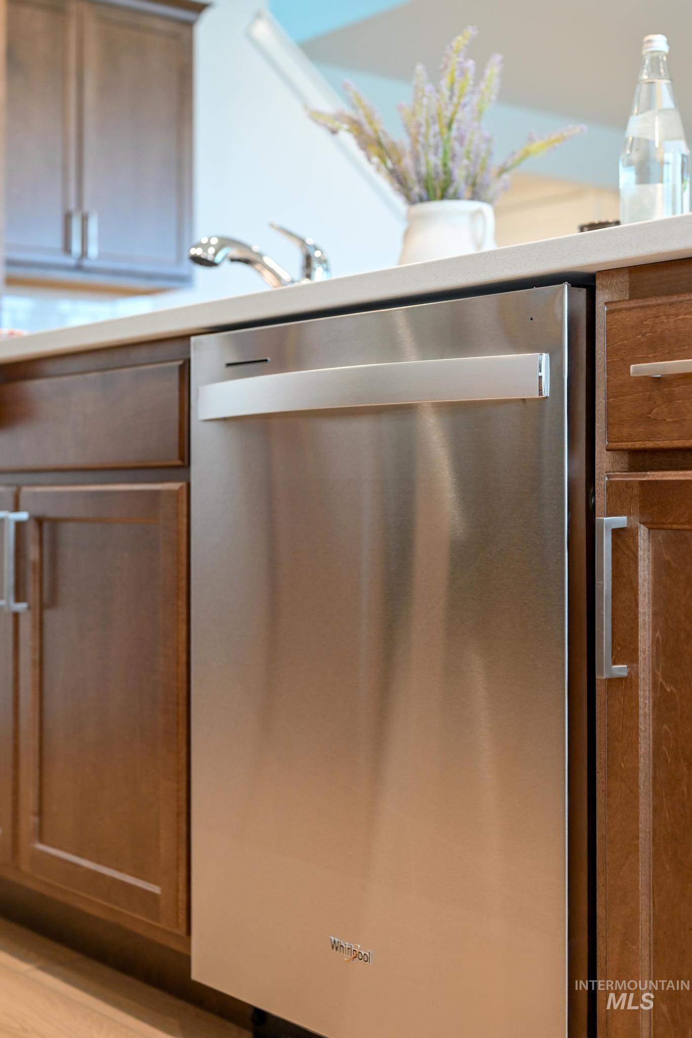 Kitchen featuring dishwasher, brown cabinets, and light countertops