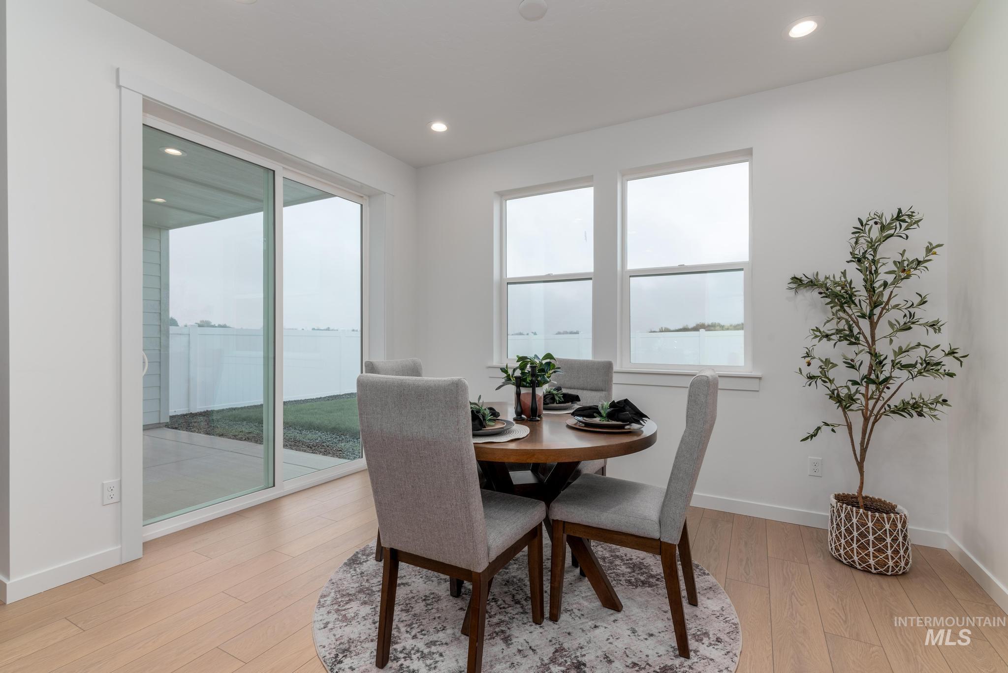Dining space with light wood finished floors and recessed lighting