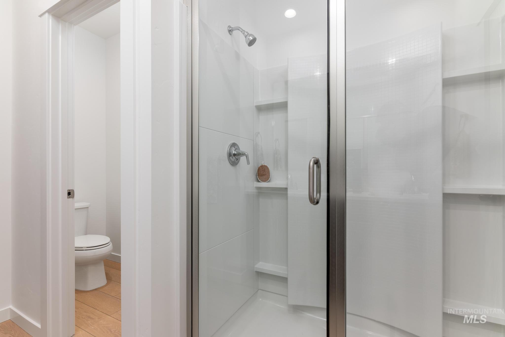 Bathroom featuring a shower stall and toilet