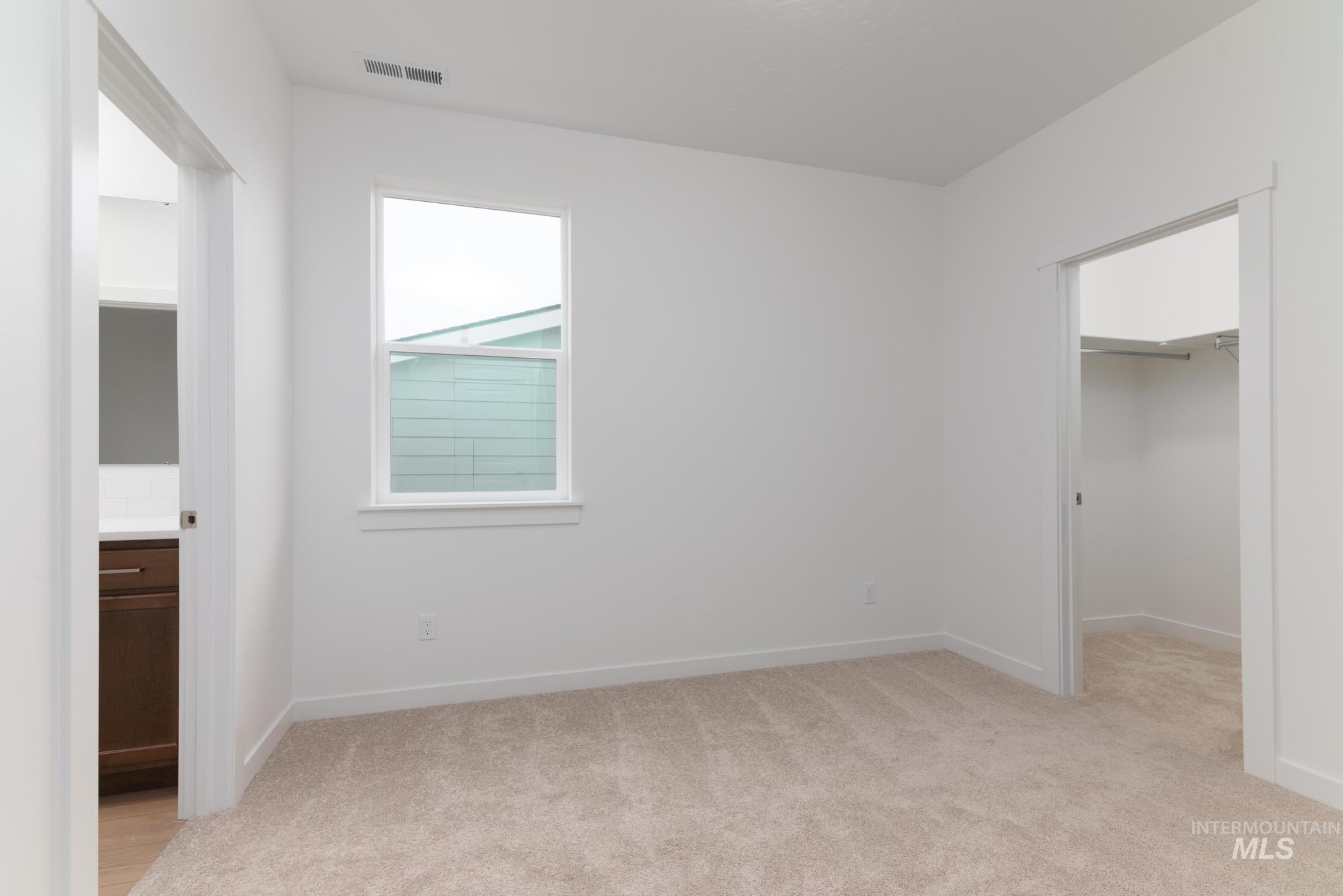 Unfurnished bedroom featuring a spacious closet and light colored carpet