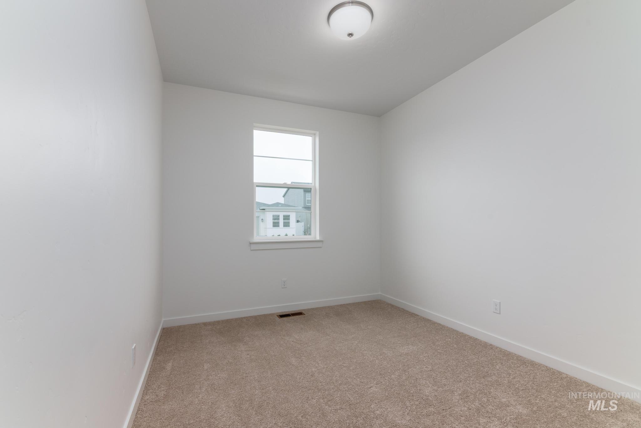 Unfurnished room featuring light colored carpet and baseboards