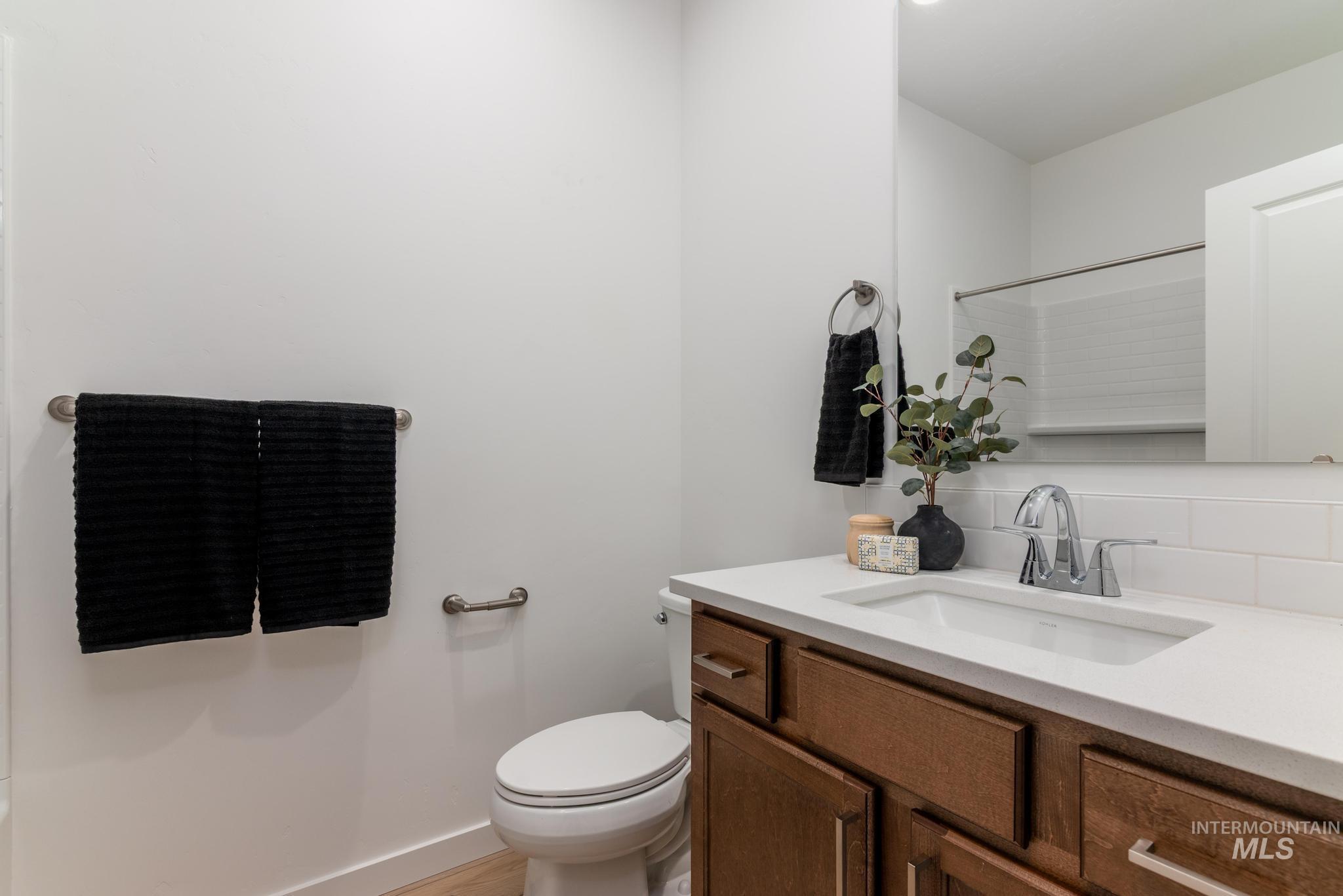 Full bathroom with vanity, a shower, and decorative backsplash