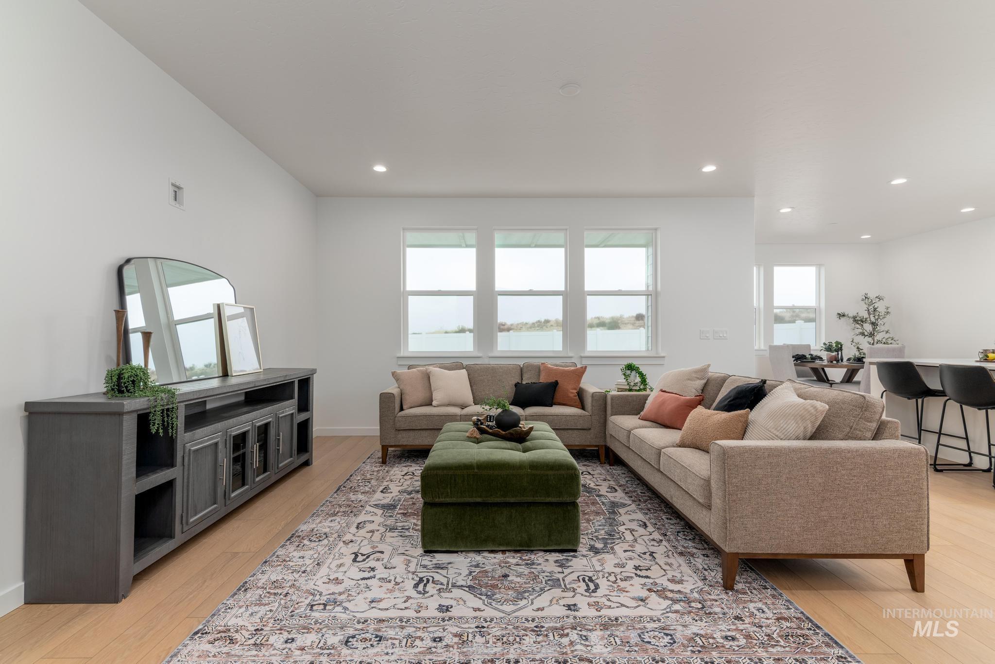 Living area with light wood-style floors and recessed lighting