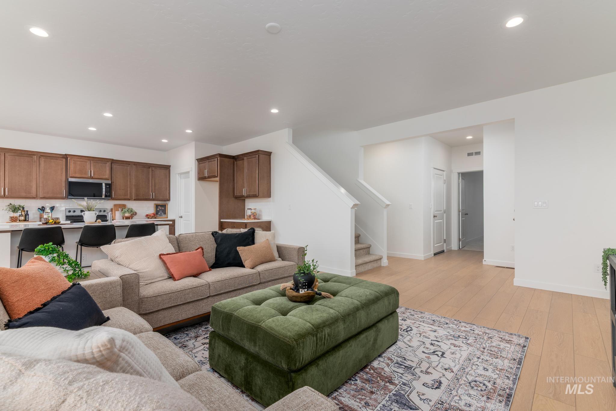 Living area with stairway, light wood finished floors, and recessed lighting