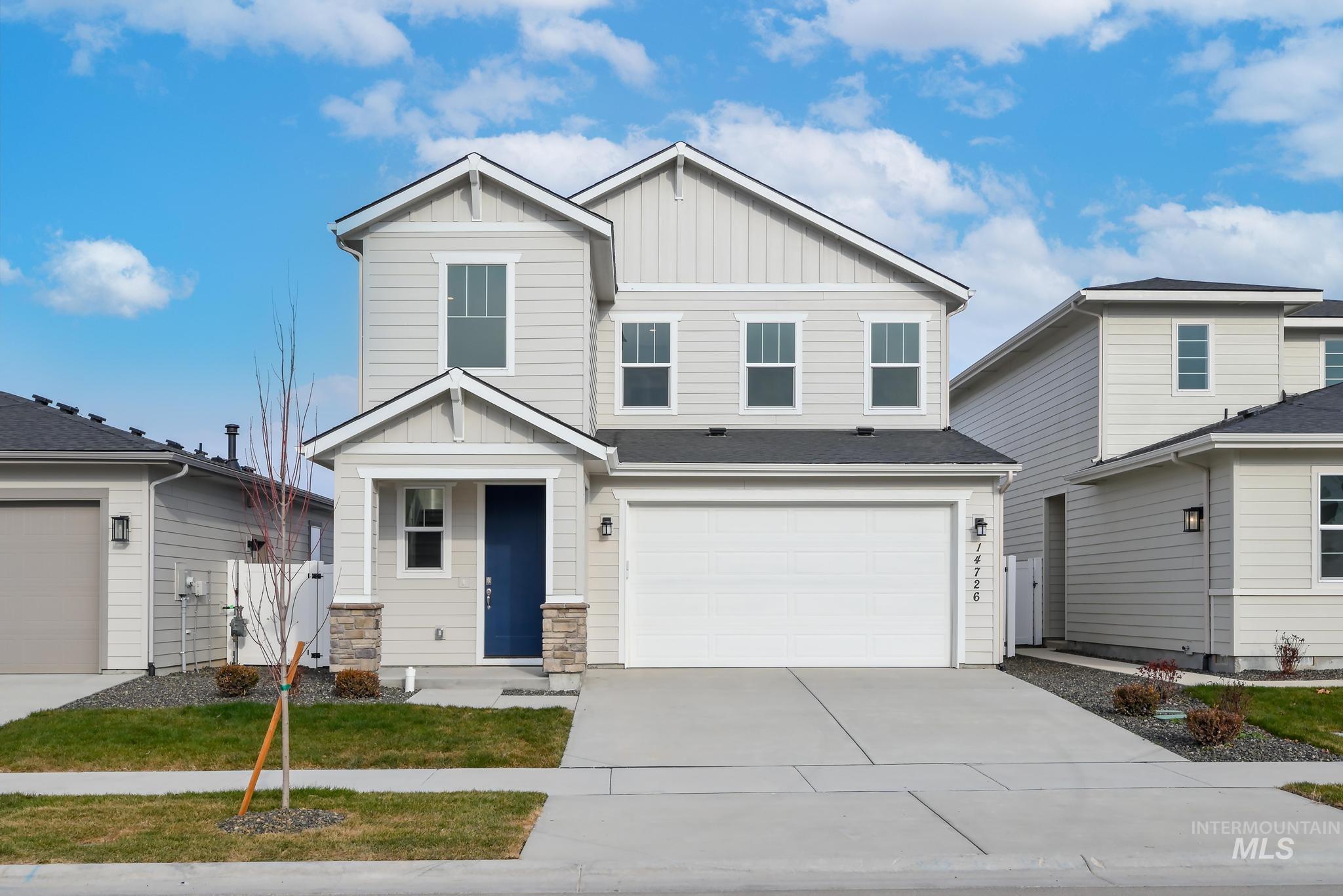 Craftsman-style home with board and batten siding, concrete driveway, stone siding, and a garage