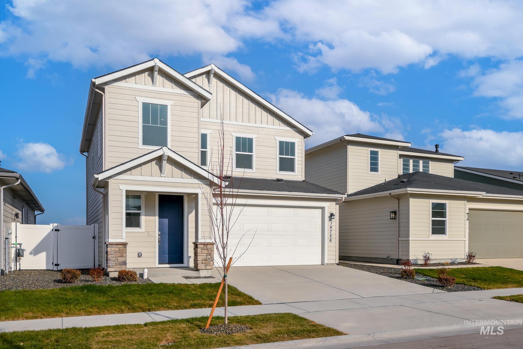 Craftsman house with a gate, board and batten siding, driveway, a garage, and stone siding