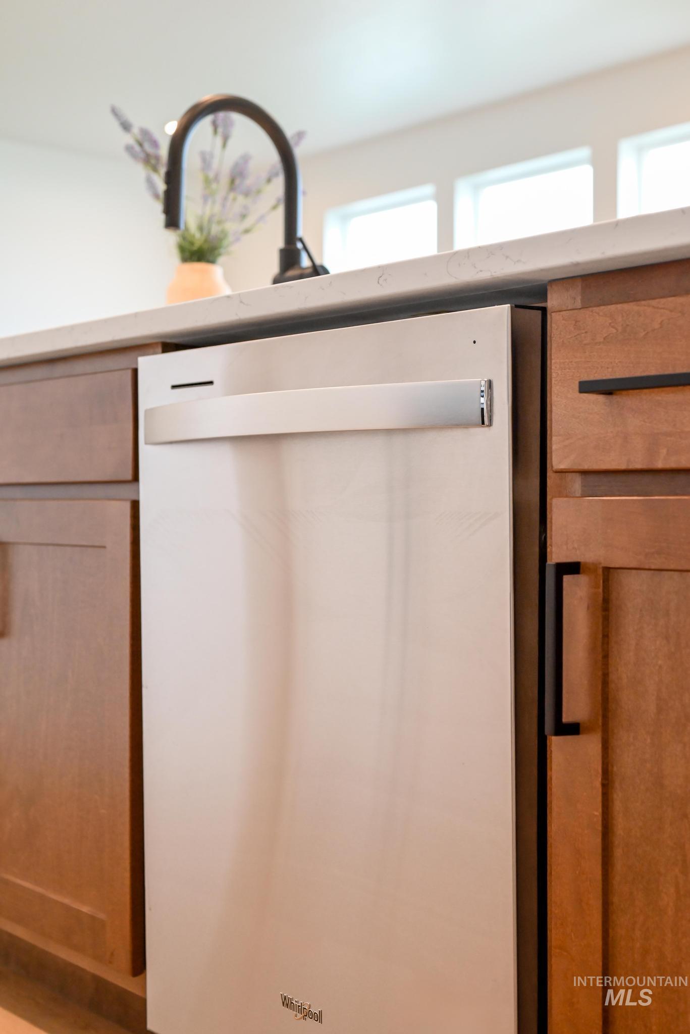Kitchen view of dishwasher and brown cabinets