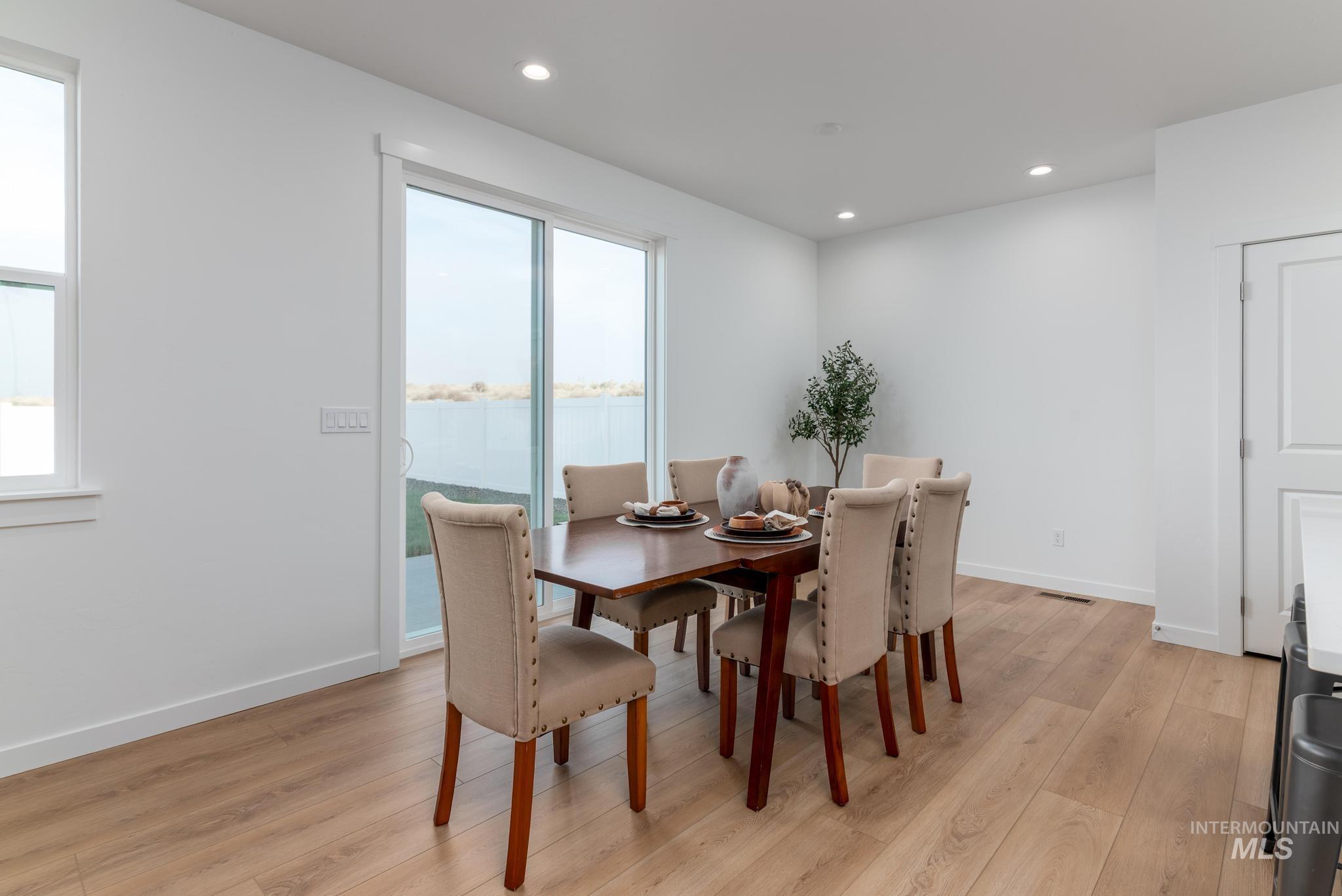Dining area featuring light wood finished floors, recessed lighting, and a water view