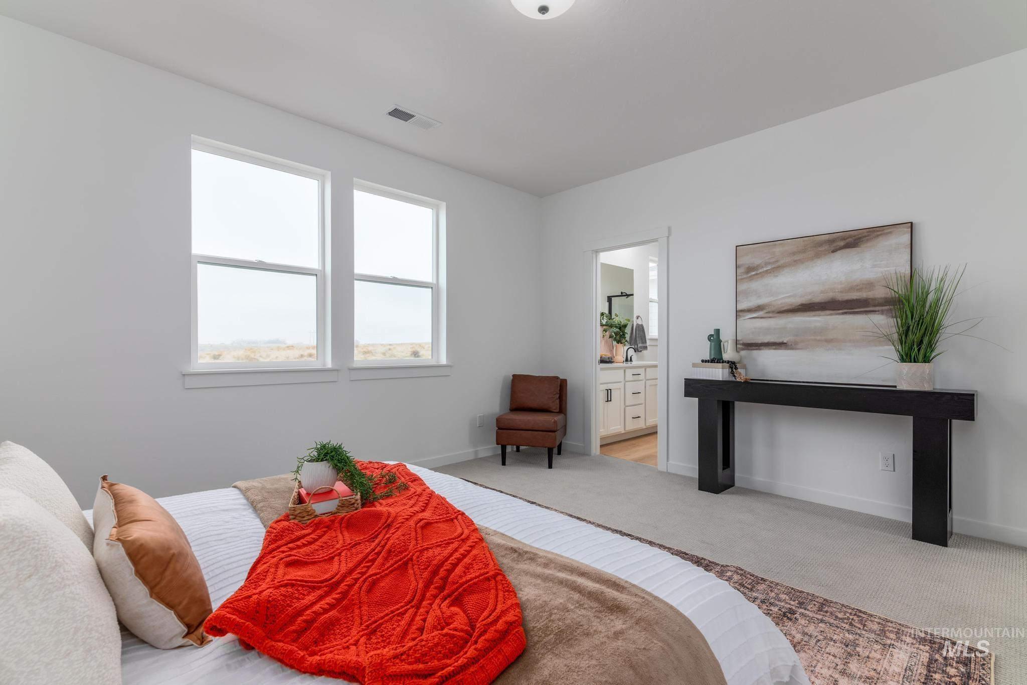 Bedroom with light colored carpet and ensuite bathroom