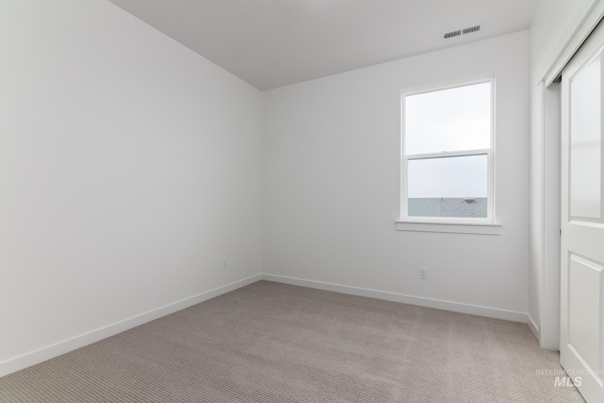 Unfurnished bedroom featuring light carpet and a closet