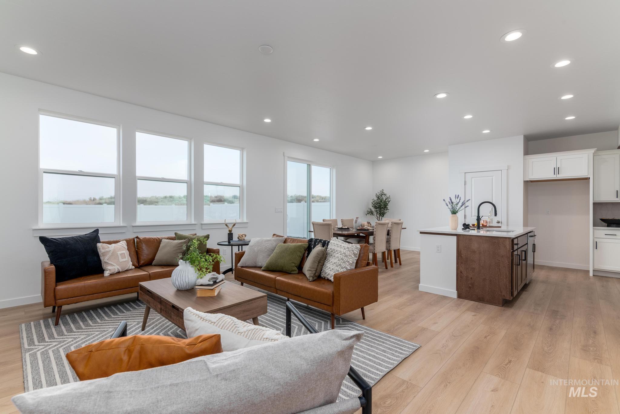 Living room featuring recessed lighting, a water view, and light wood-style flooring