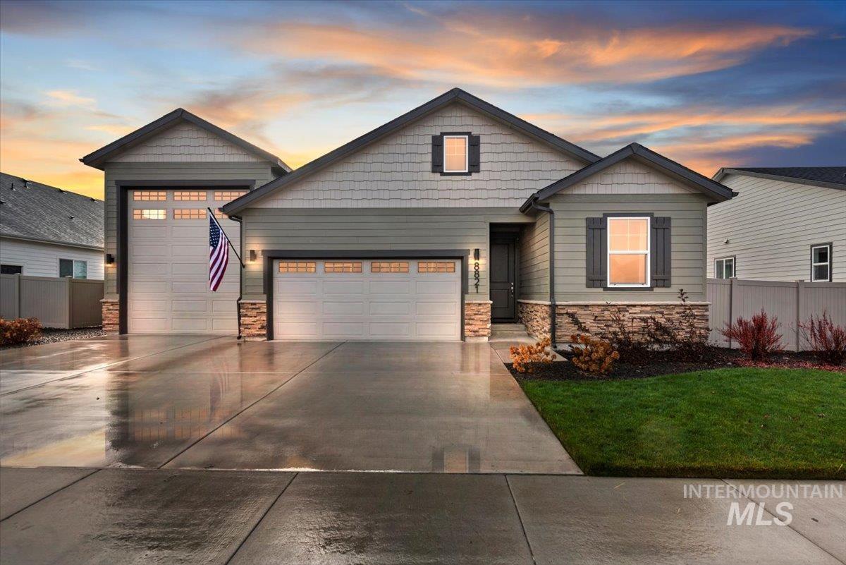 Craftsman house featuring stone siding, concrete driveway, and an attached garage