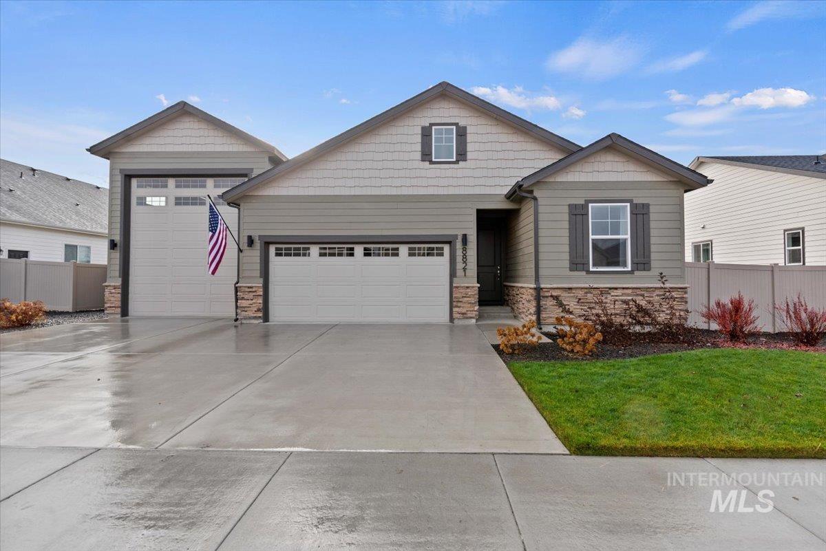 Craftsman house with stone siding, concrete driveway, and a garage
