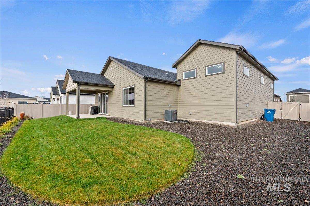 Rear view of house featuring a fenced backyard and a patio area