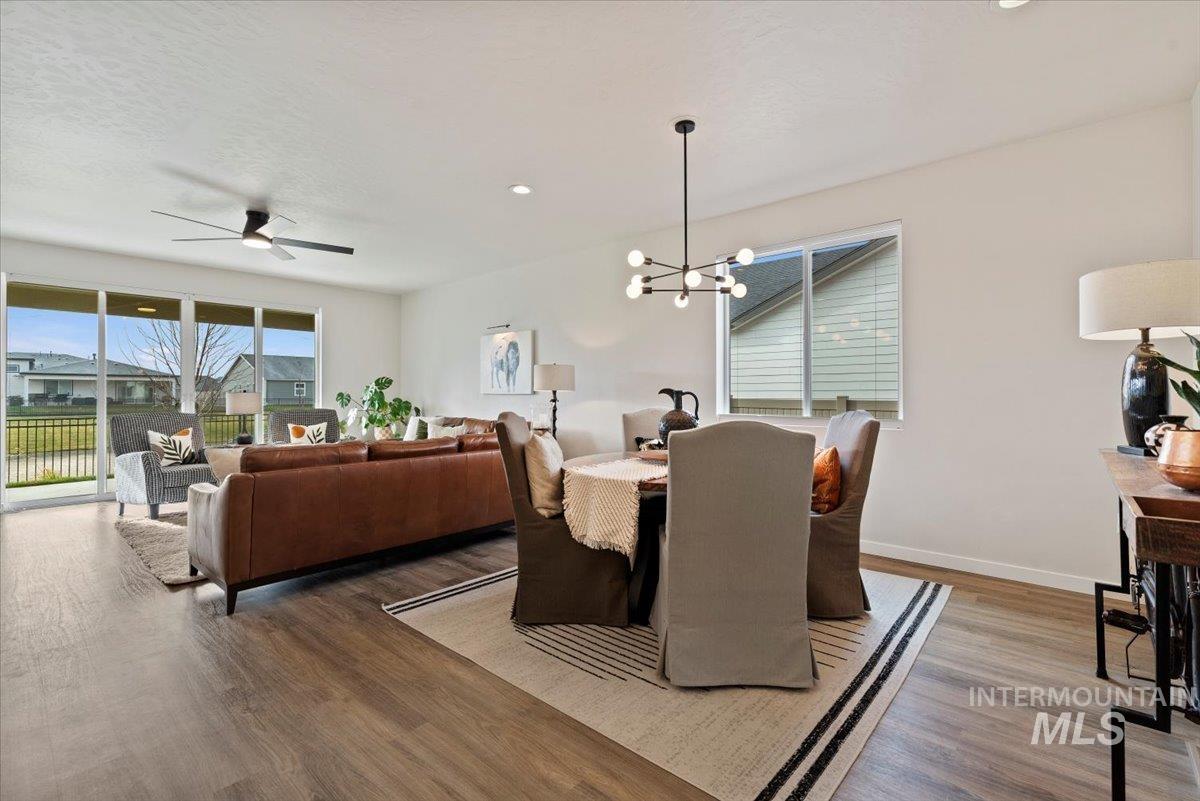 Dining area with a chandelier, light wood-style flooring, healthy amount of natural light, ceiling fan, and recessed lighting