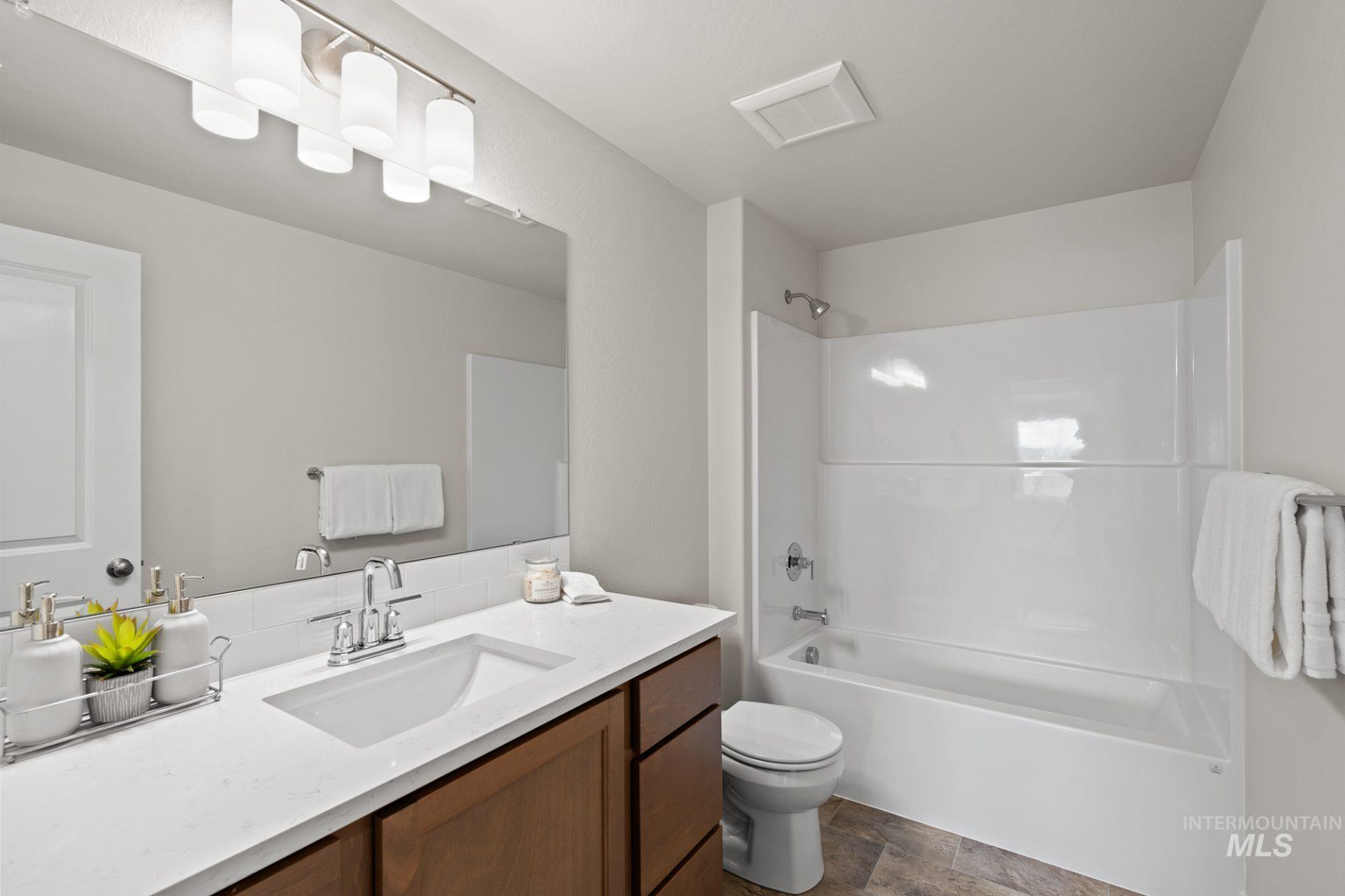Bathroom featuring vanity and washtub / shower combination