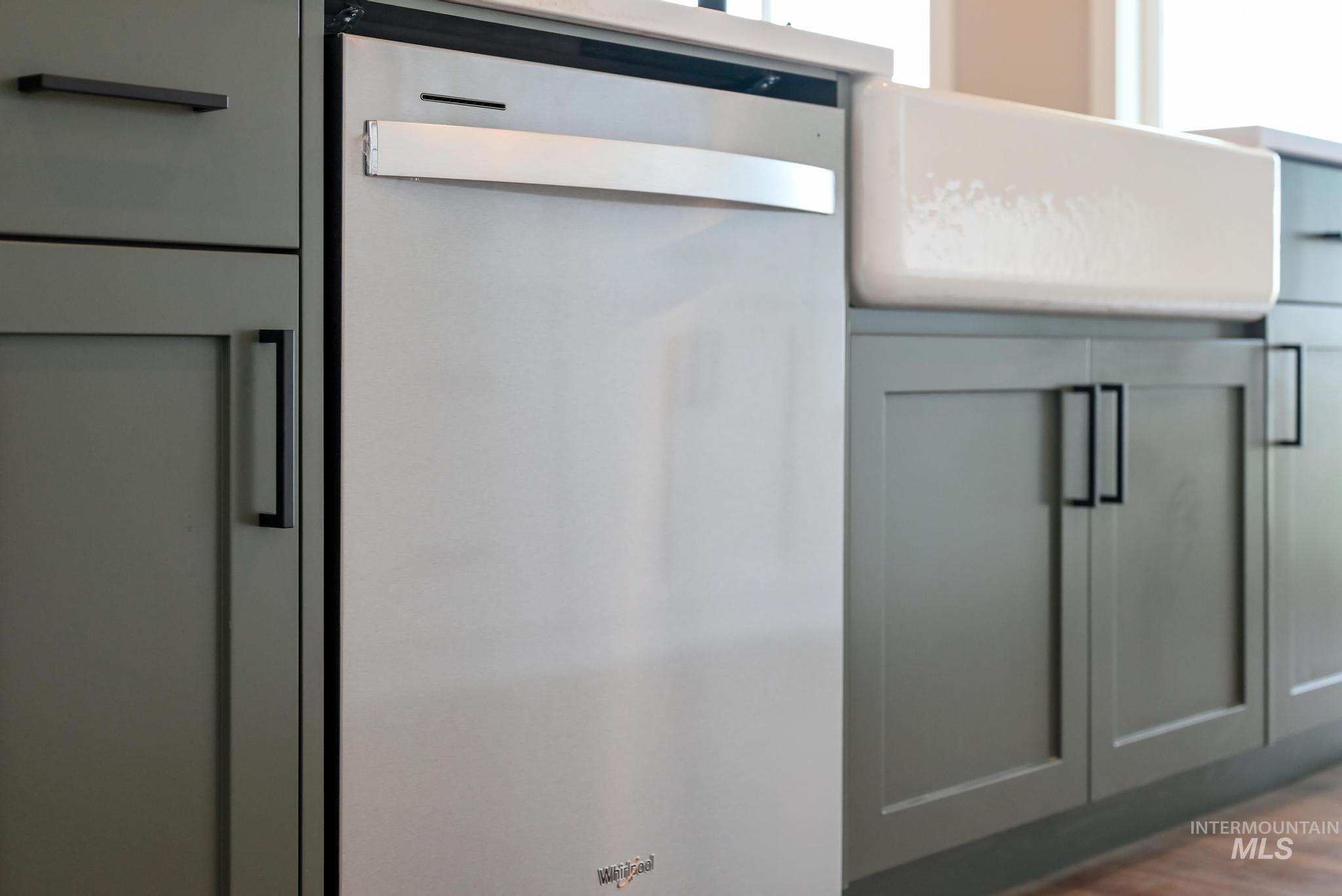 Kitchen view of dishwasher, gray cabinets, and dark wood-style floors