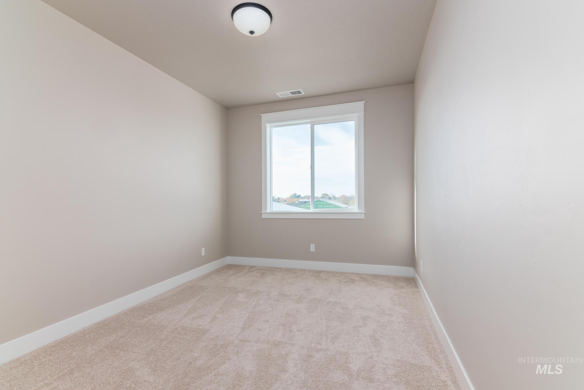 Spare room featuring baseboards and light carpet