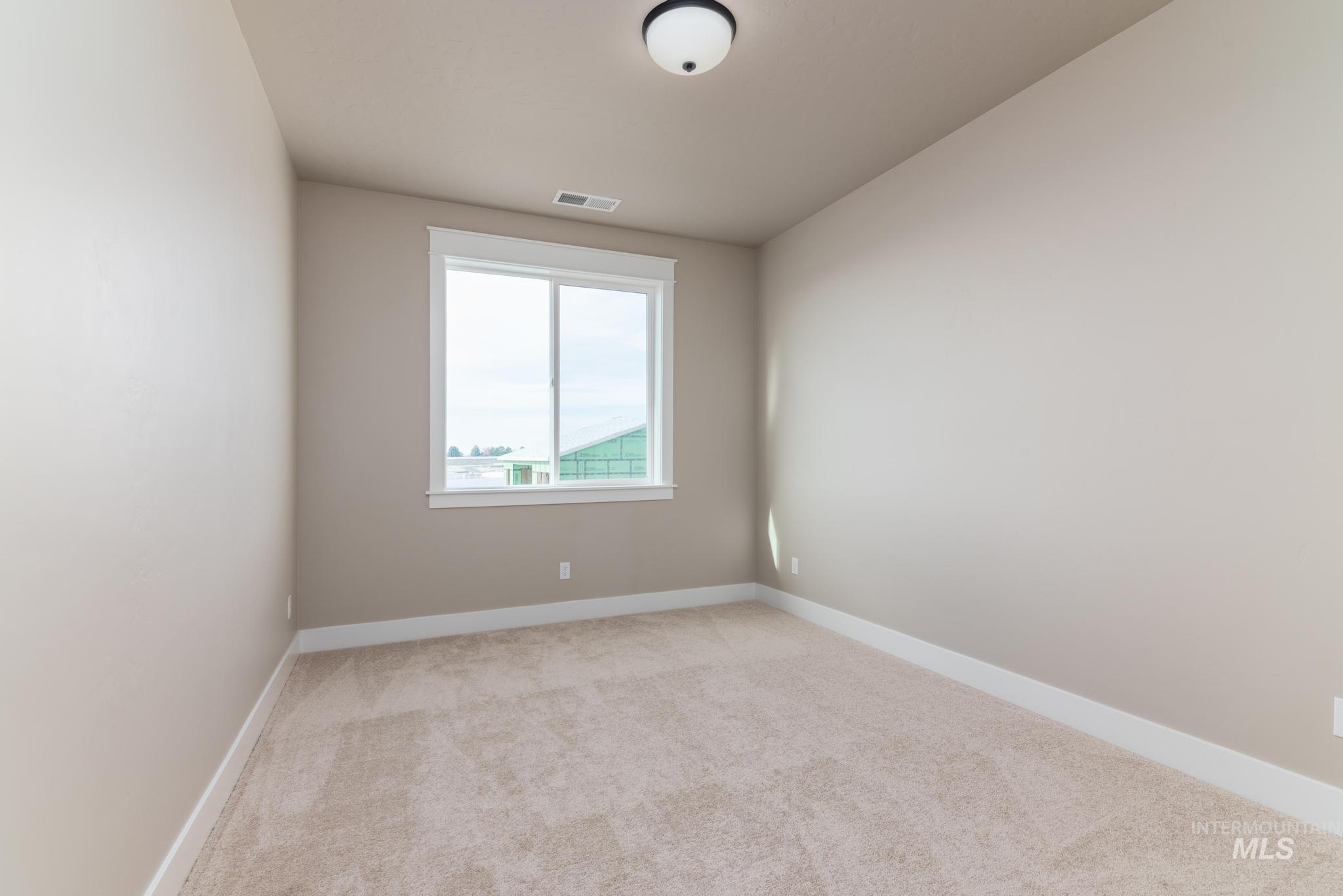 Spare room featuring baseboards and light carpet