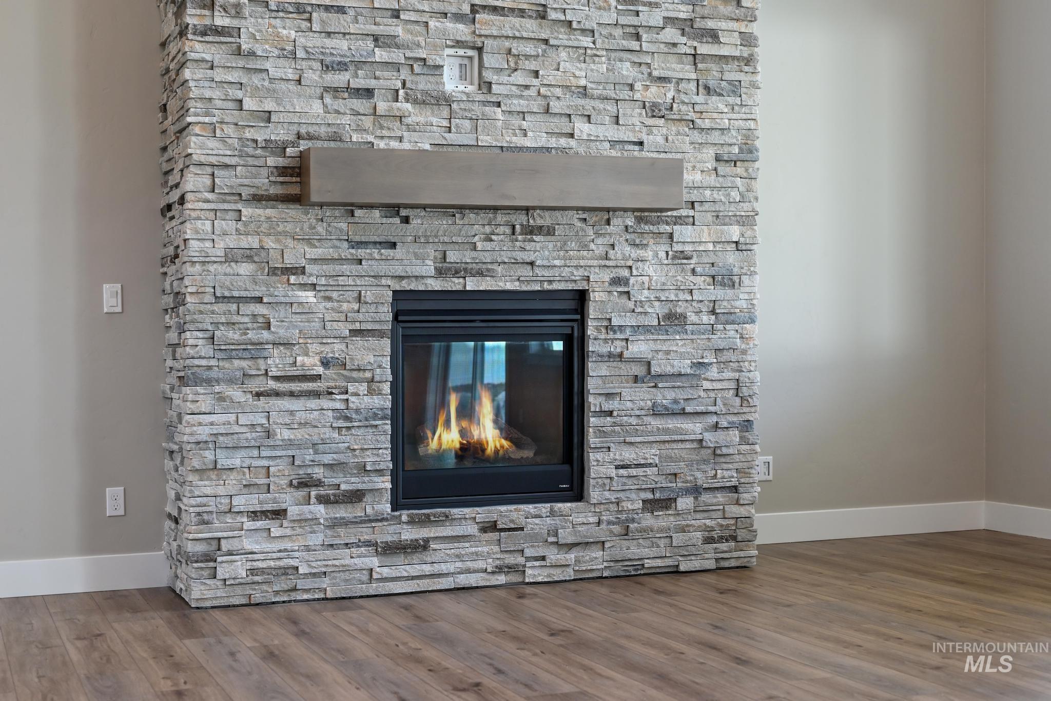 Detailed view of a stone fireplace and wood finished floors