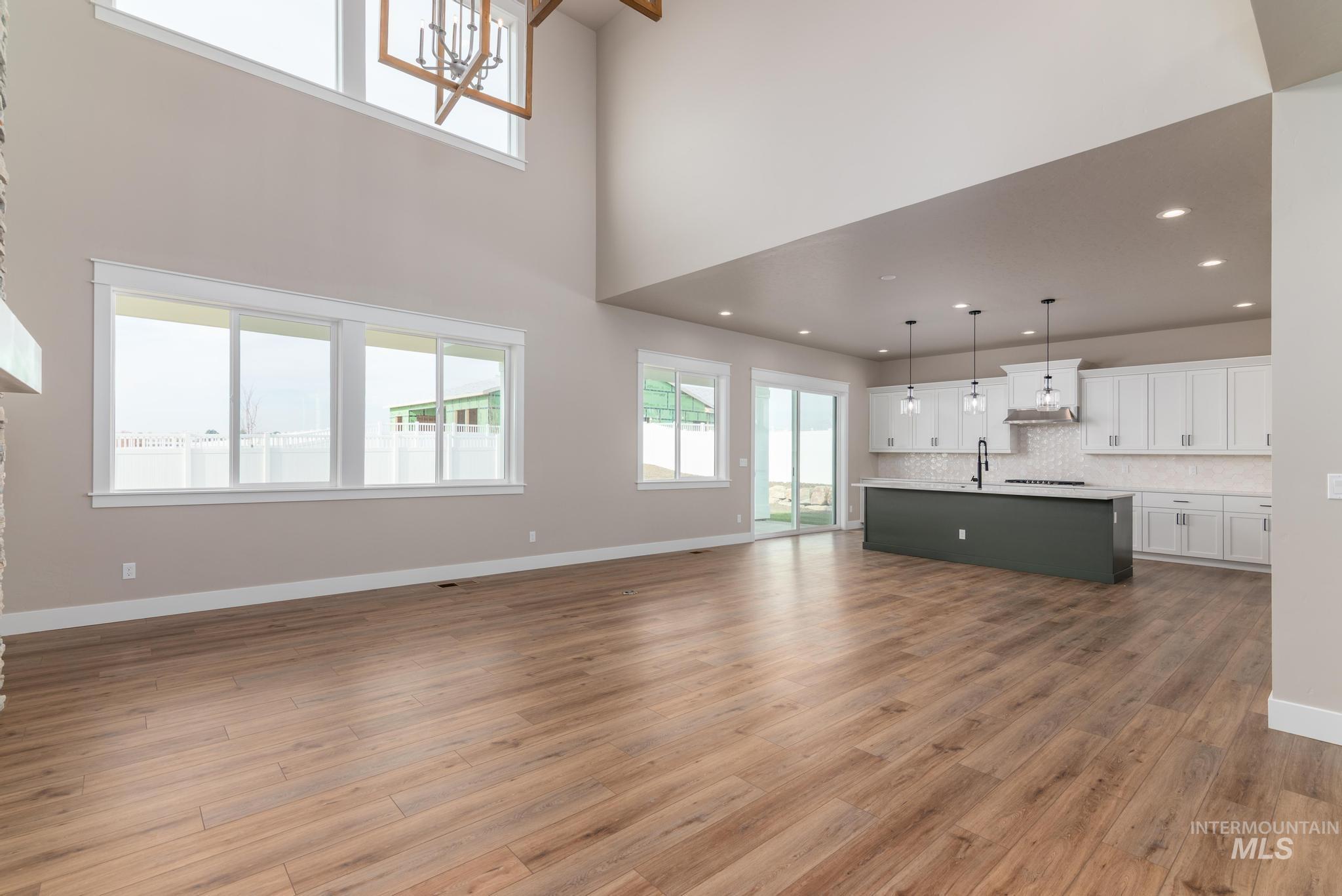 Unfurnished living room featuring dark wood finished floors and a chandelier
