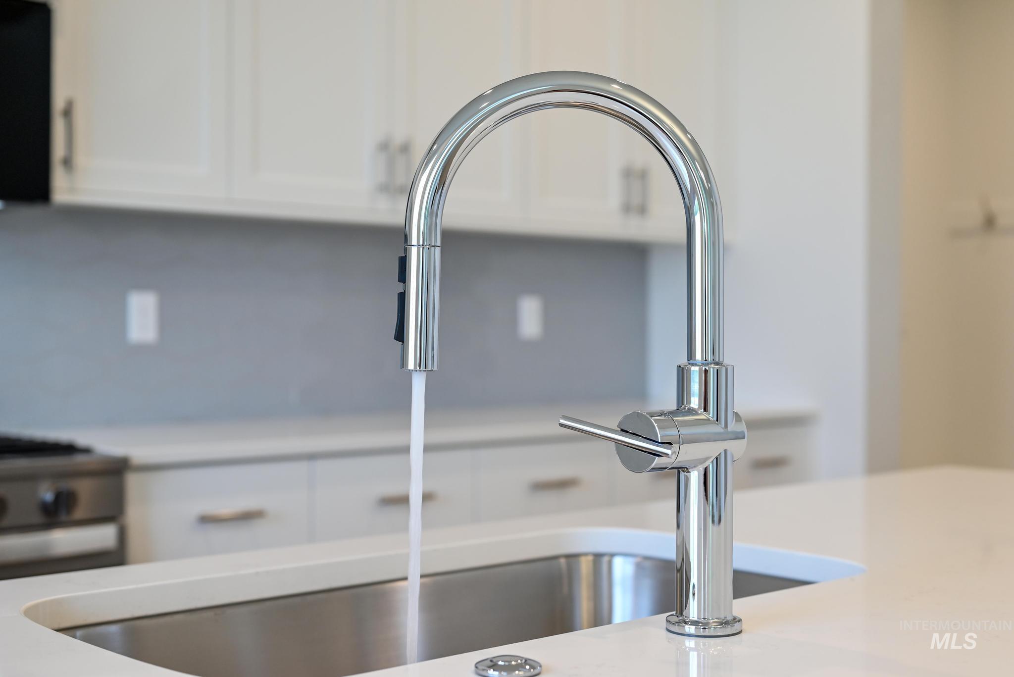 Kitchen view of white cabinets and light stone countertops