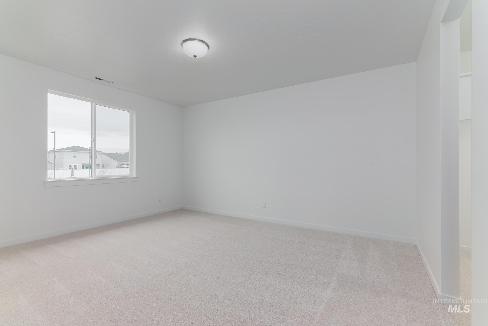 Spare room featuring light carpet