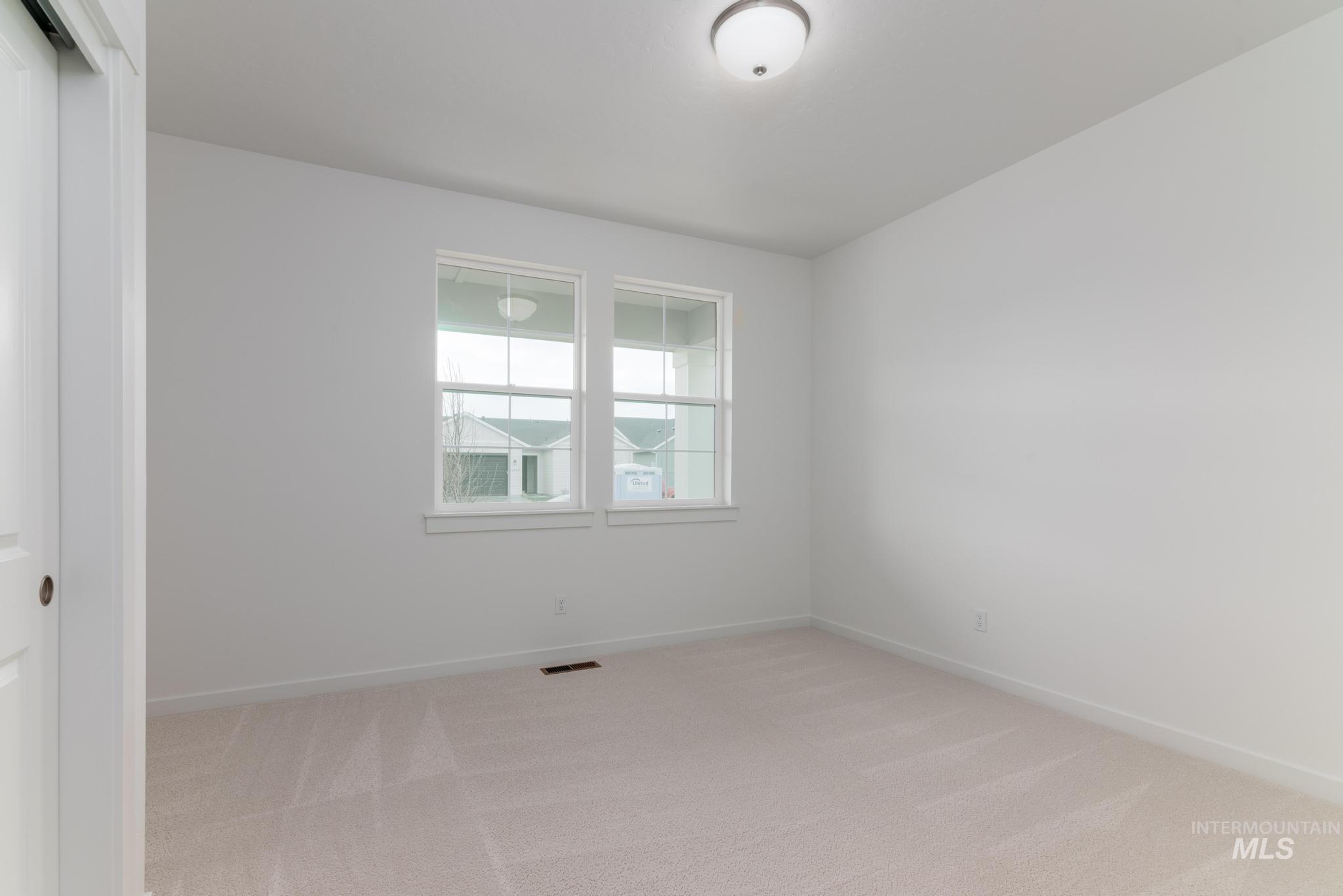 Unfurnished room with light carpet and baseboards