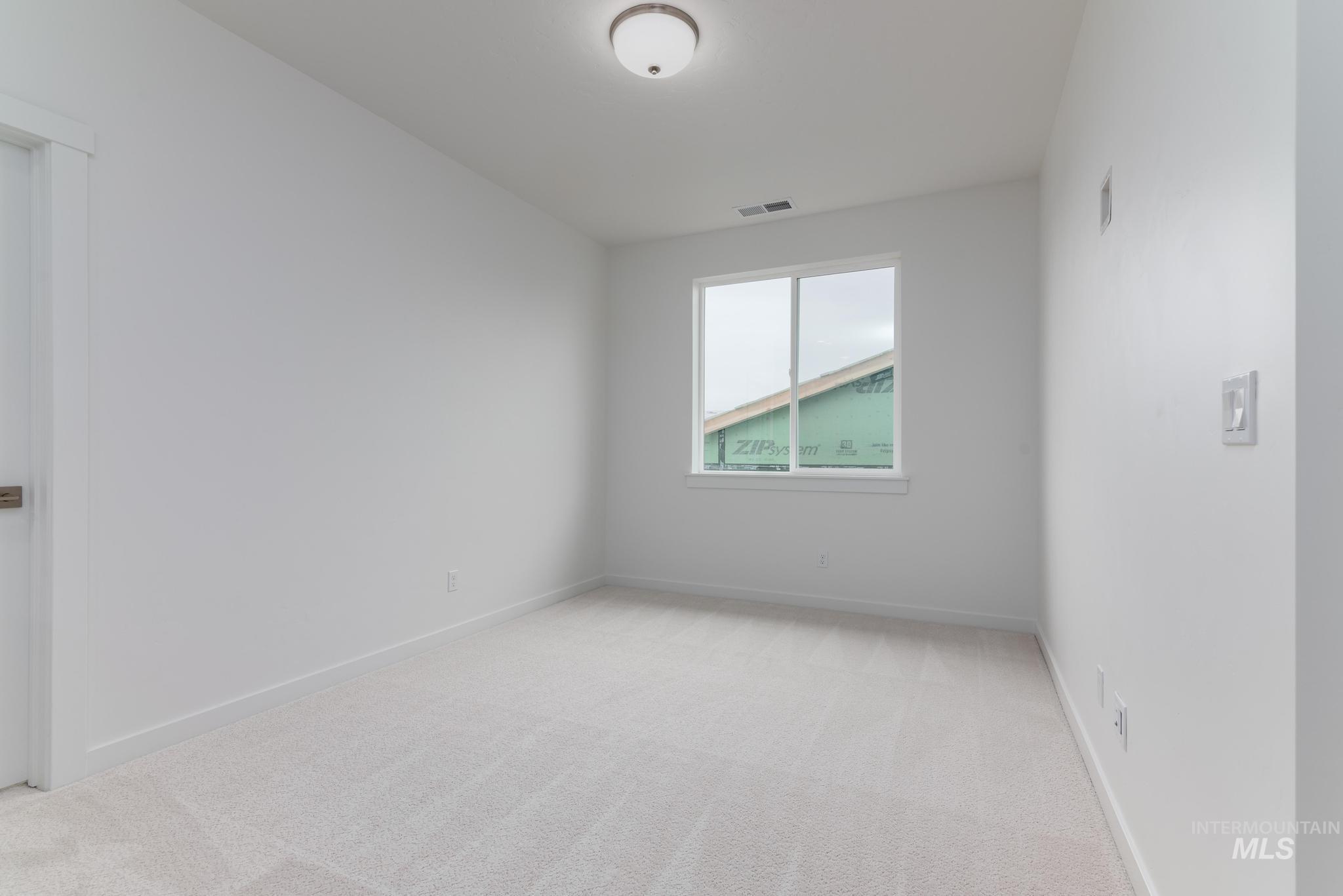 Unfurnished room with light colored carpet and baseboards