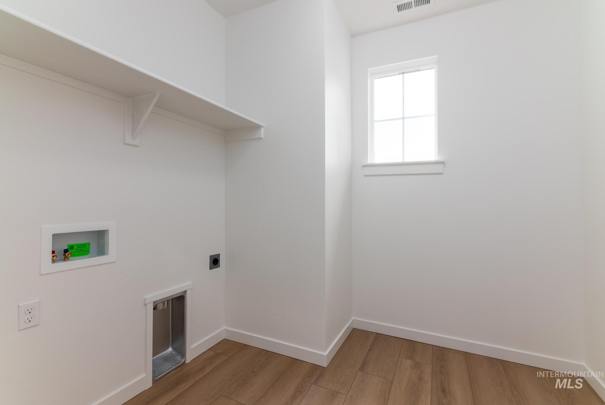 Laundry area with light wood-type flooring, electric dryer hookup, and washer hookup