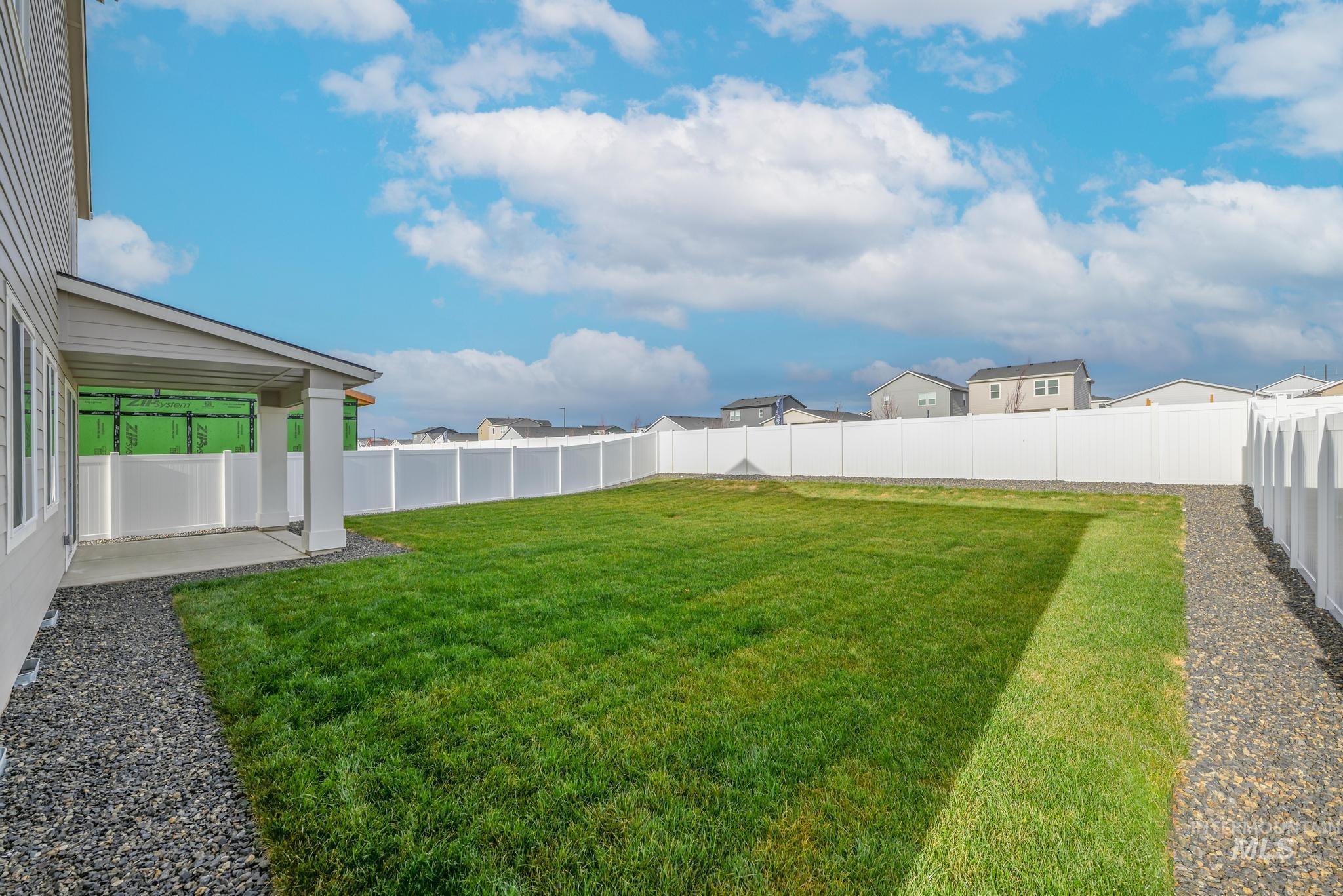 Fenced backyard with a patio area and a residential view