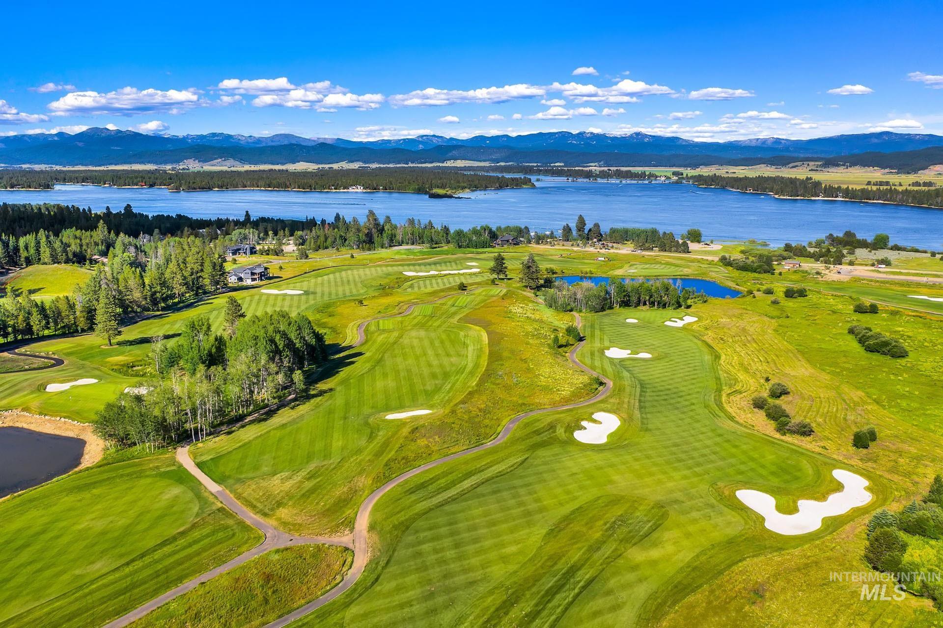 Drone / aerial view of a water and mountain view and a golf course