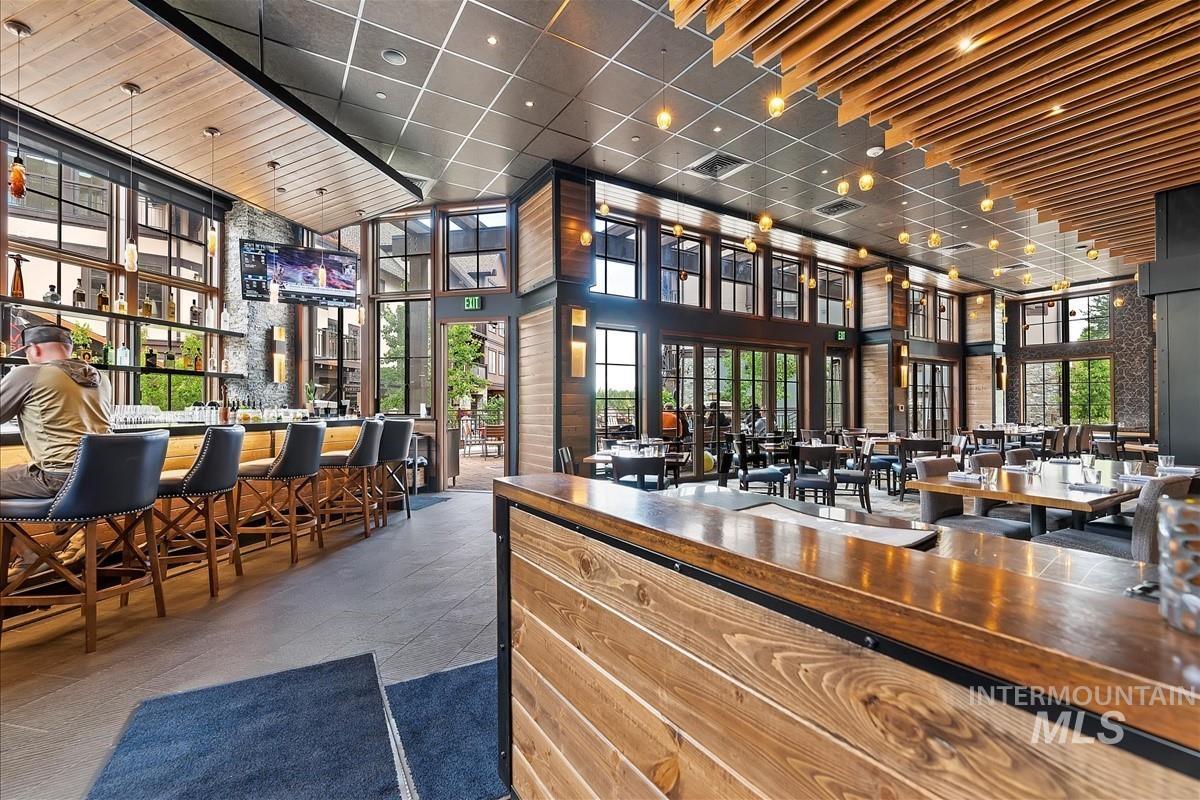 Indoor wet bar with a high ceiling, a paneled ceiling, plenty of natural light, and butcher block counters