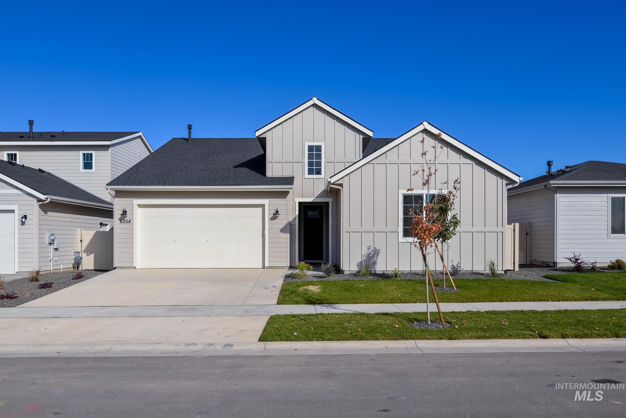 Modern farmhouse with board and batten siding, driveway, and an attached garage