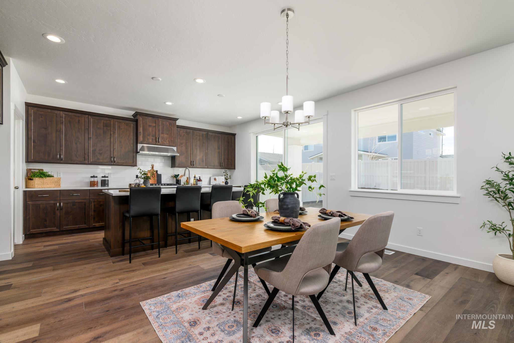 Dining area featuring recessed lighting, dark wood-style flooring, and a chandelier