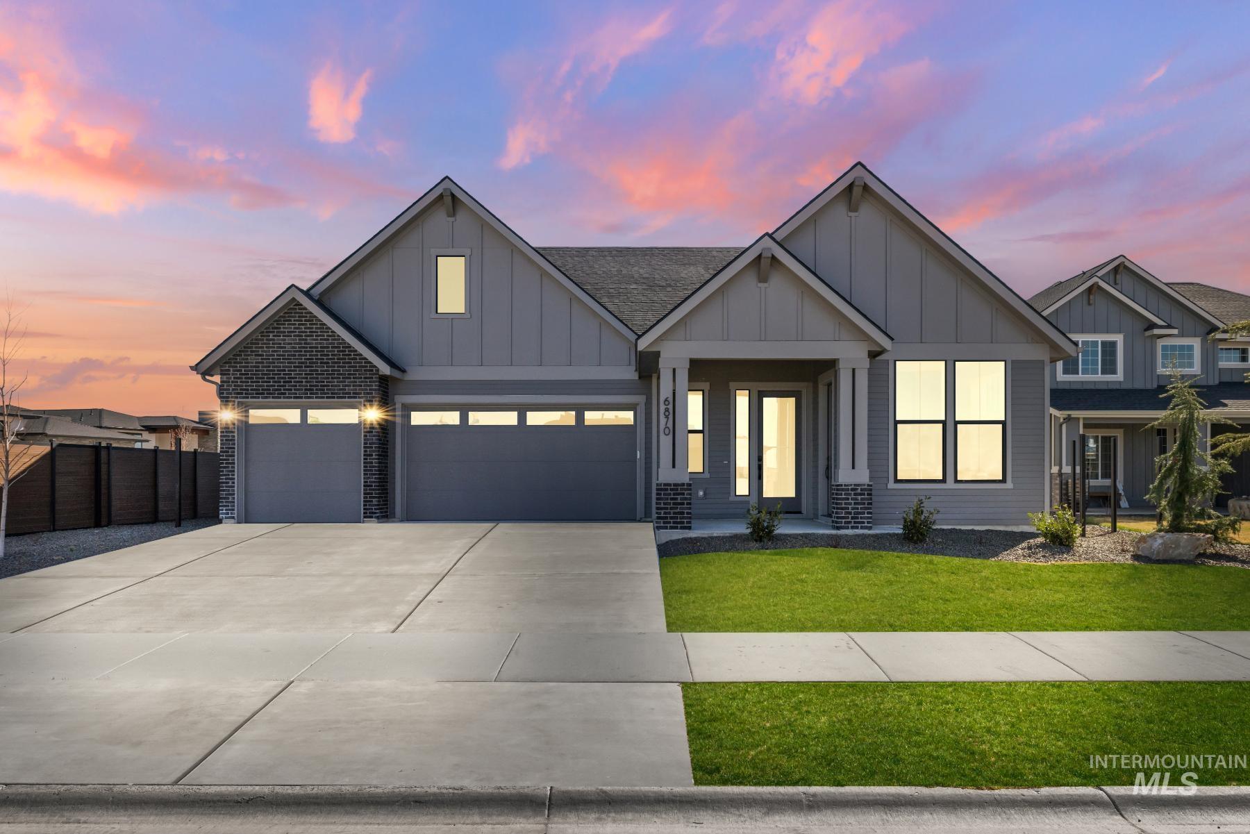 Modern farmhouse style home with board and batten siding, driveway, an attached garage, and roof with shingles