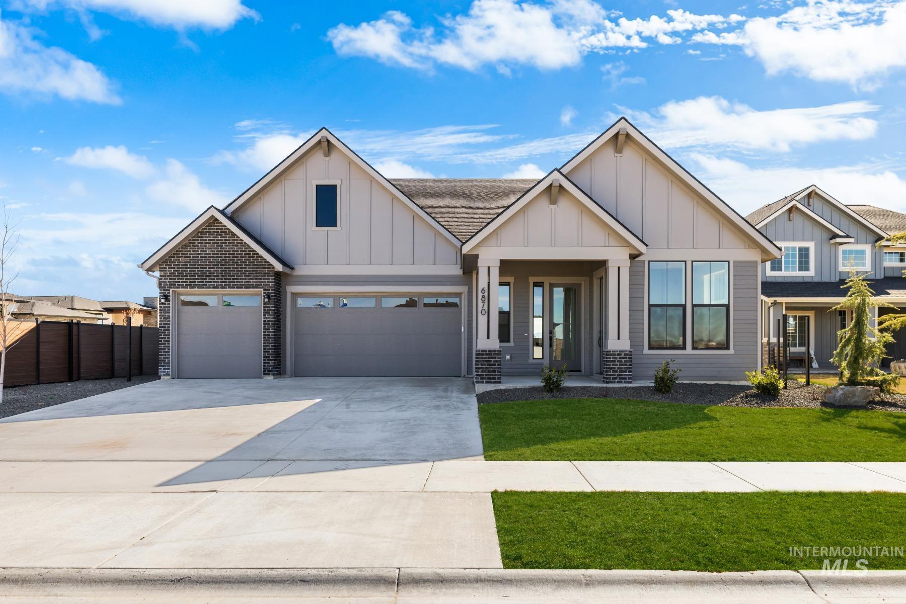 View of front of property with board and batten siding, driveway, a porch, and roof with shingles