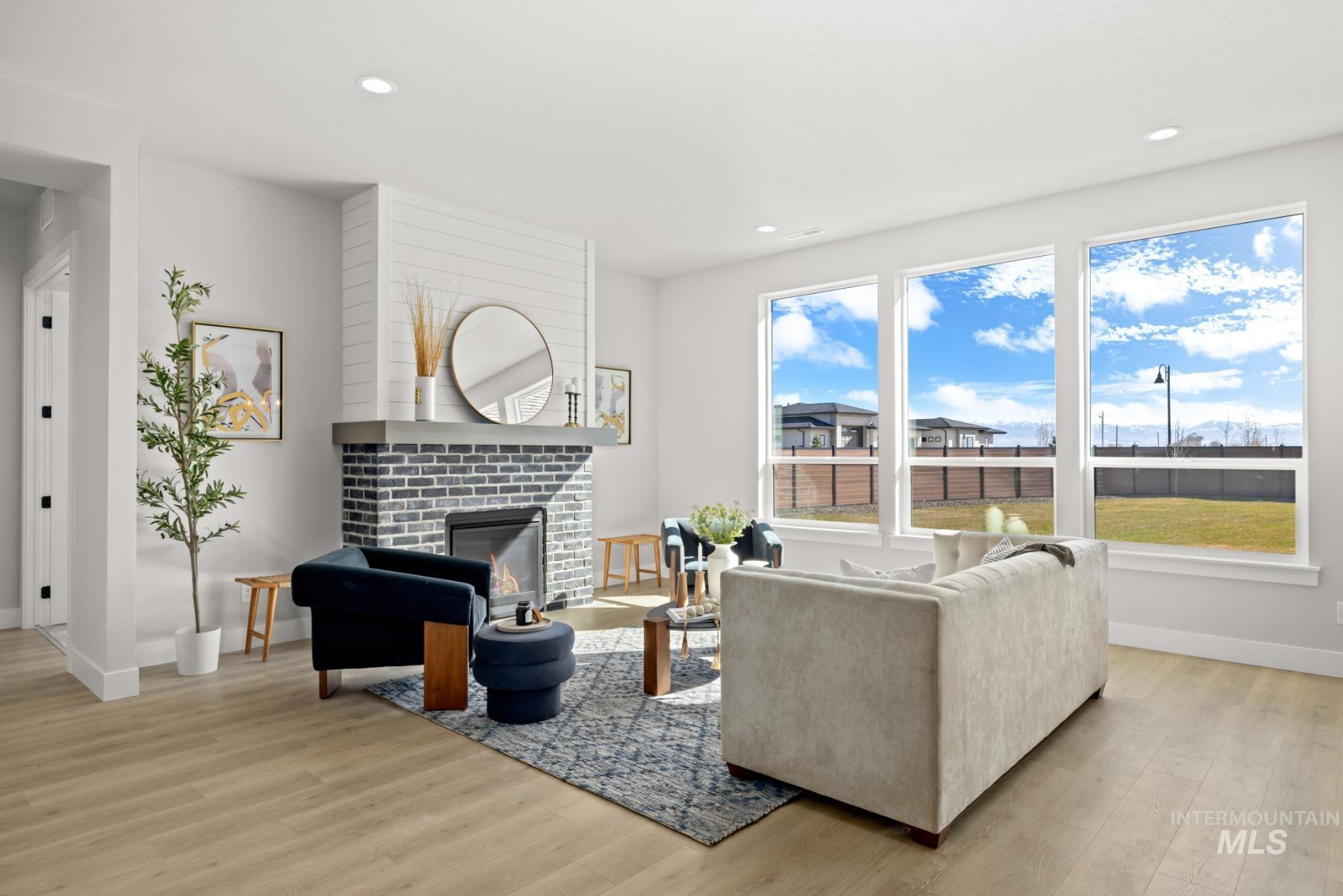 Living room with a glass covered fireplace, light wood-type flooring, and recessed lighting