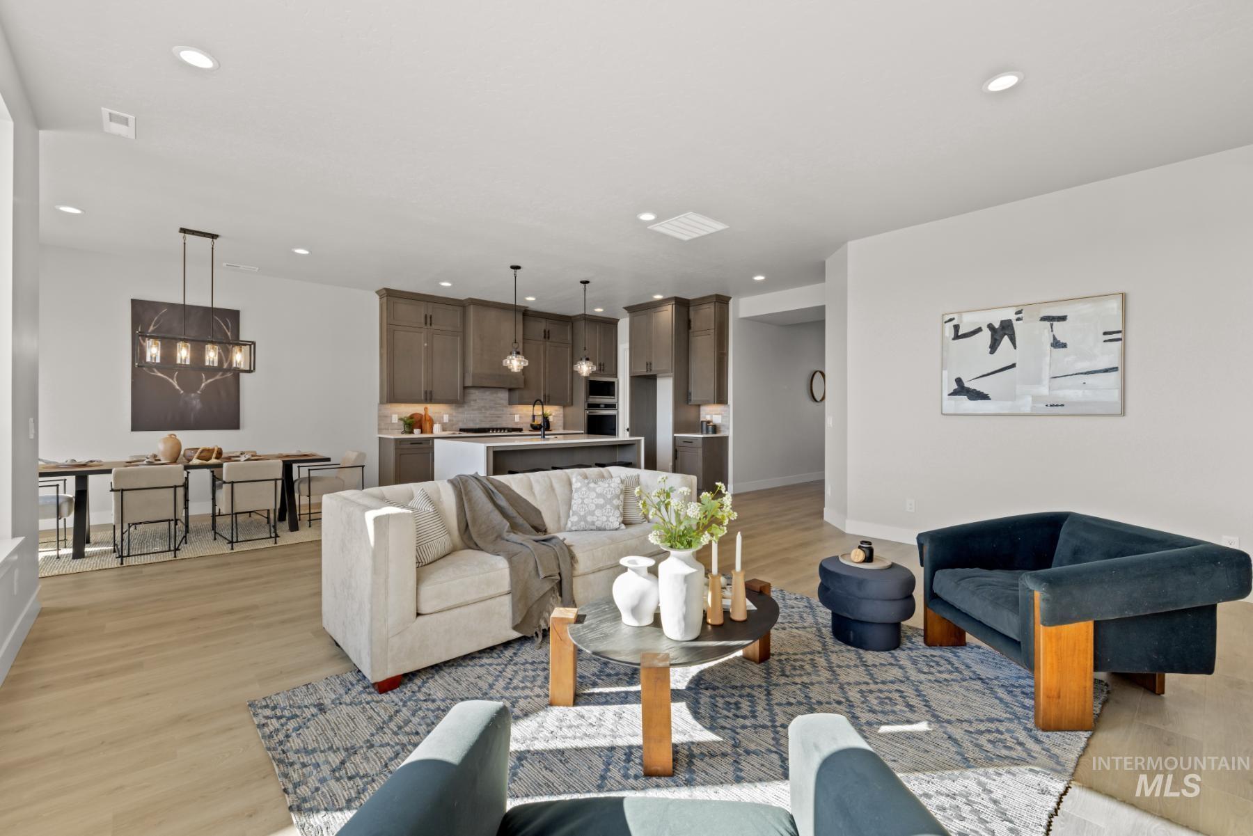 Living area with light wood-style floors, recessed lighting, and a chandelier