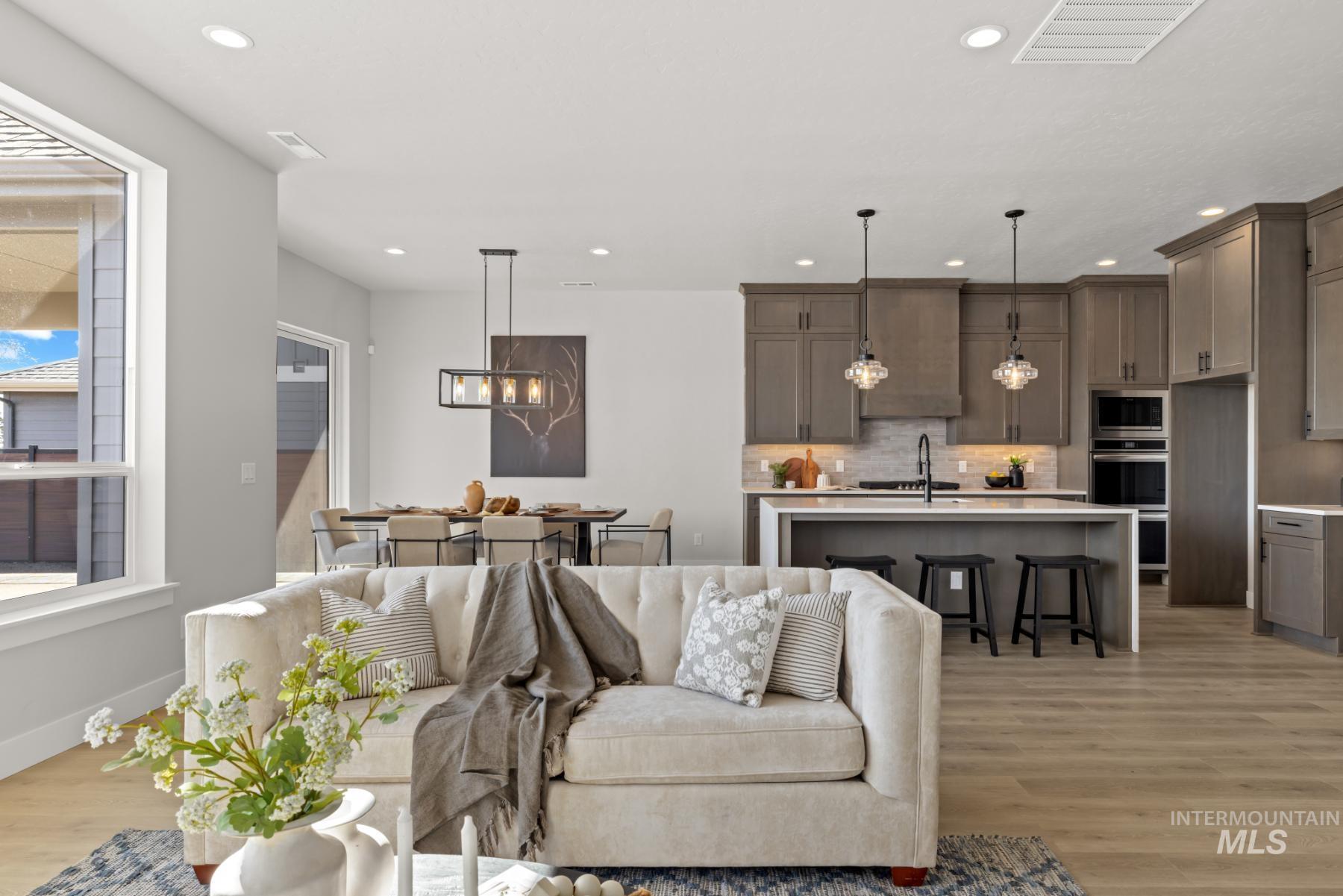 Living room featuring a chandelier, light wood-type flooring, and recessed lighting