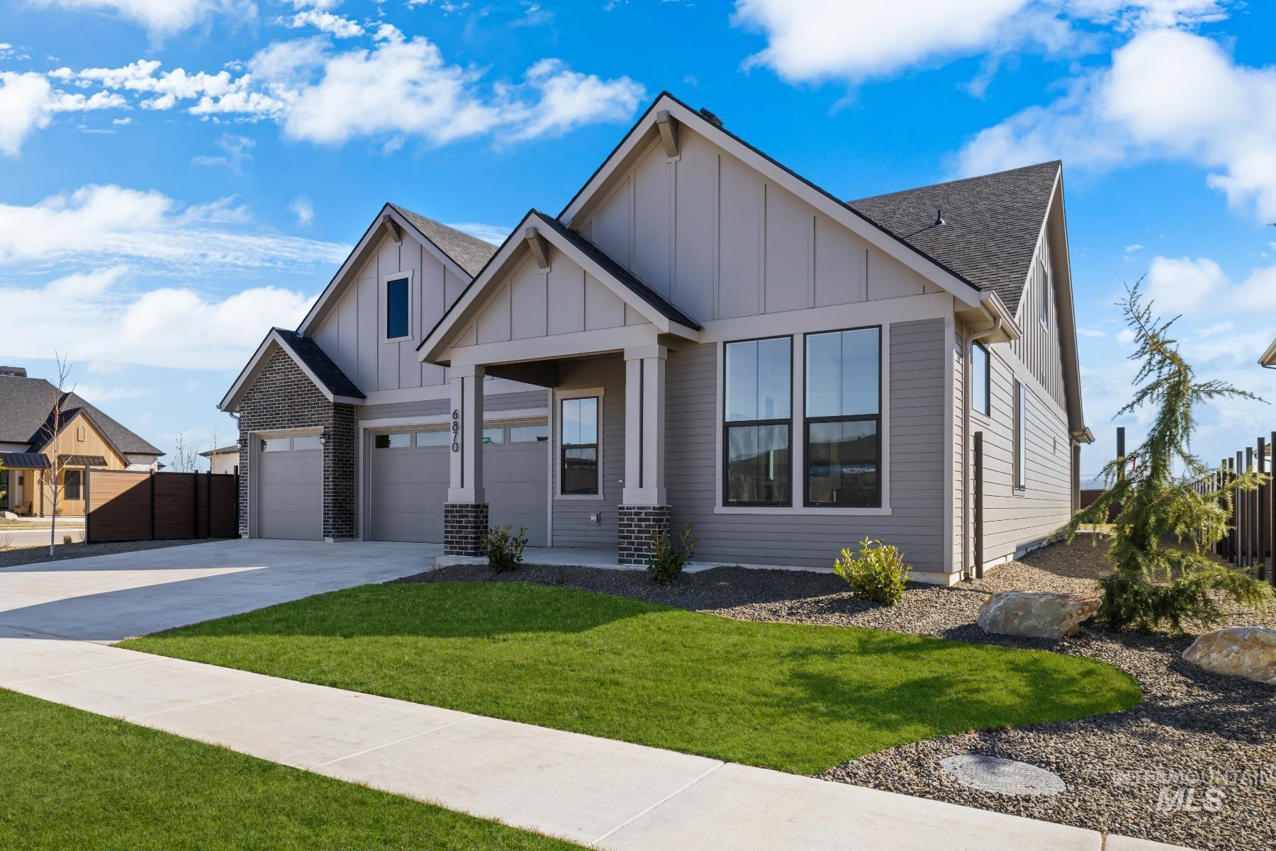 Modern inspired farmhouse with board and batten siding, a shingled roof, concrete driveway, and an attached garage