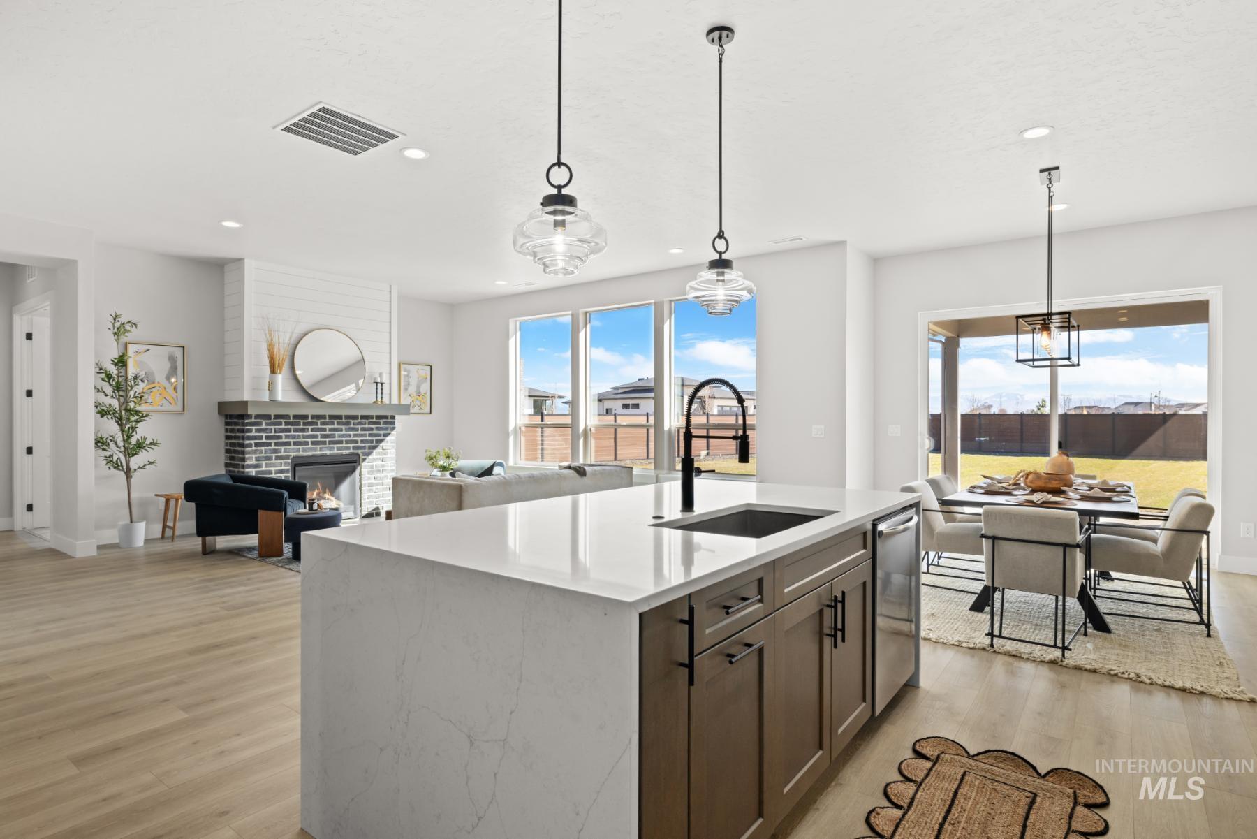 Kitchen with decorative light fixtures, light stone countertops, open floor plan, healthy amount of natural light, and recessed lighting